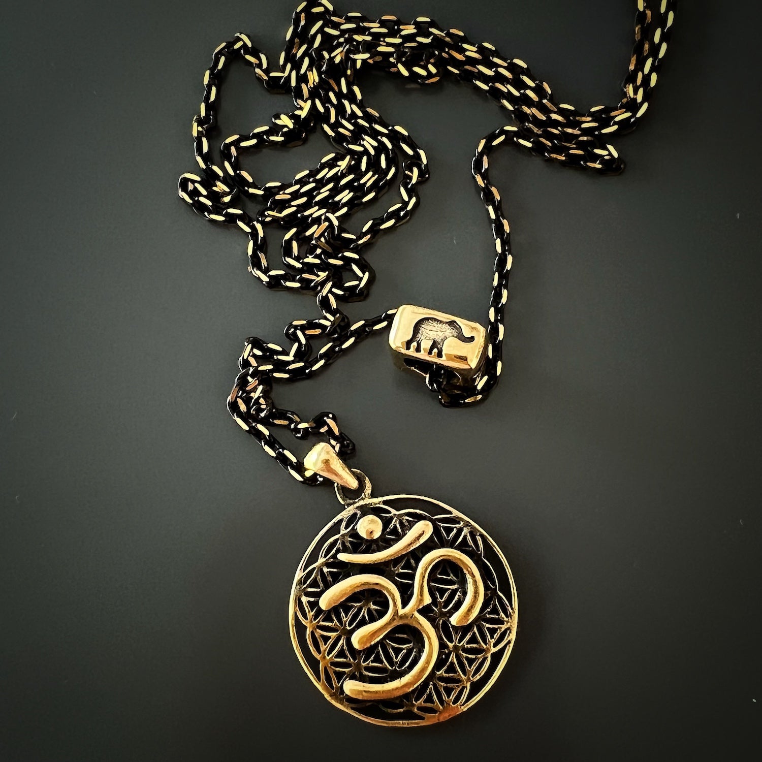 The elegant Spiritual Symbols Om Necklace, crafted with 925 Sterling Silver and 18k gold plating, adding a touch of sophistication to any outfit.