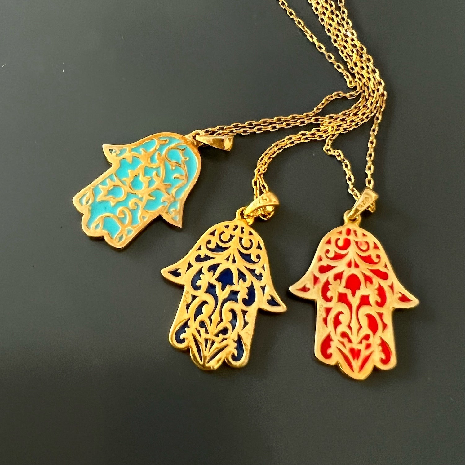 The Stay Positive Hamsa Necklace exudes style and spirituality, with its vibrant hamsa pendant made of sterling silver and 18K gold plating with colorful enamel accents, reminding you to stay positive.