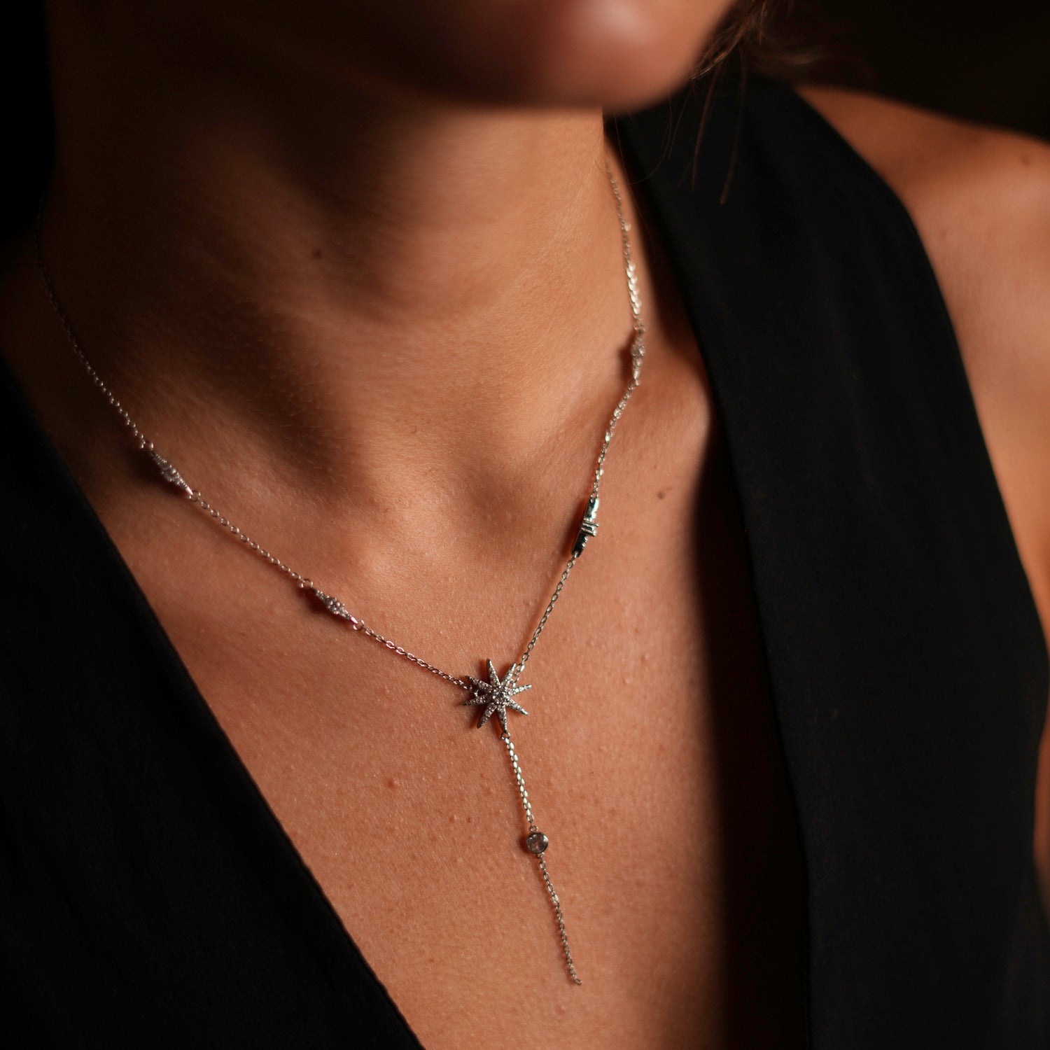 Elegant sterling silver necklace with a star pendant and diamond details, including diamonds cascading from the chain for added brilliance.