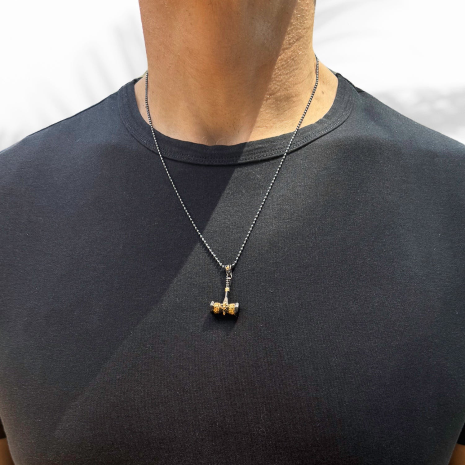 Handcrafted men's necklace with a sterling silver chain and a gold-plated hammer pendant adorned with a fleur de lis symbol