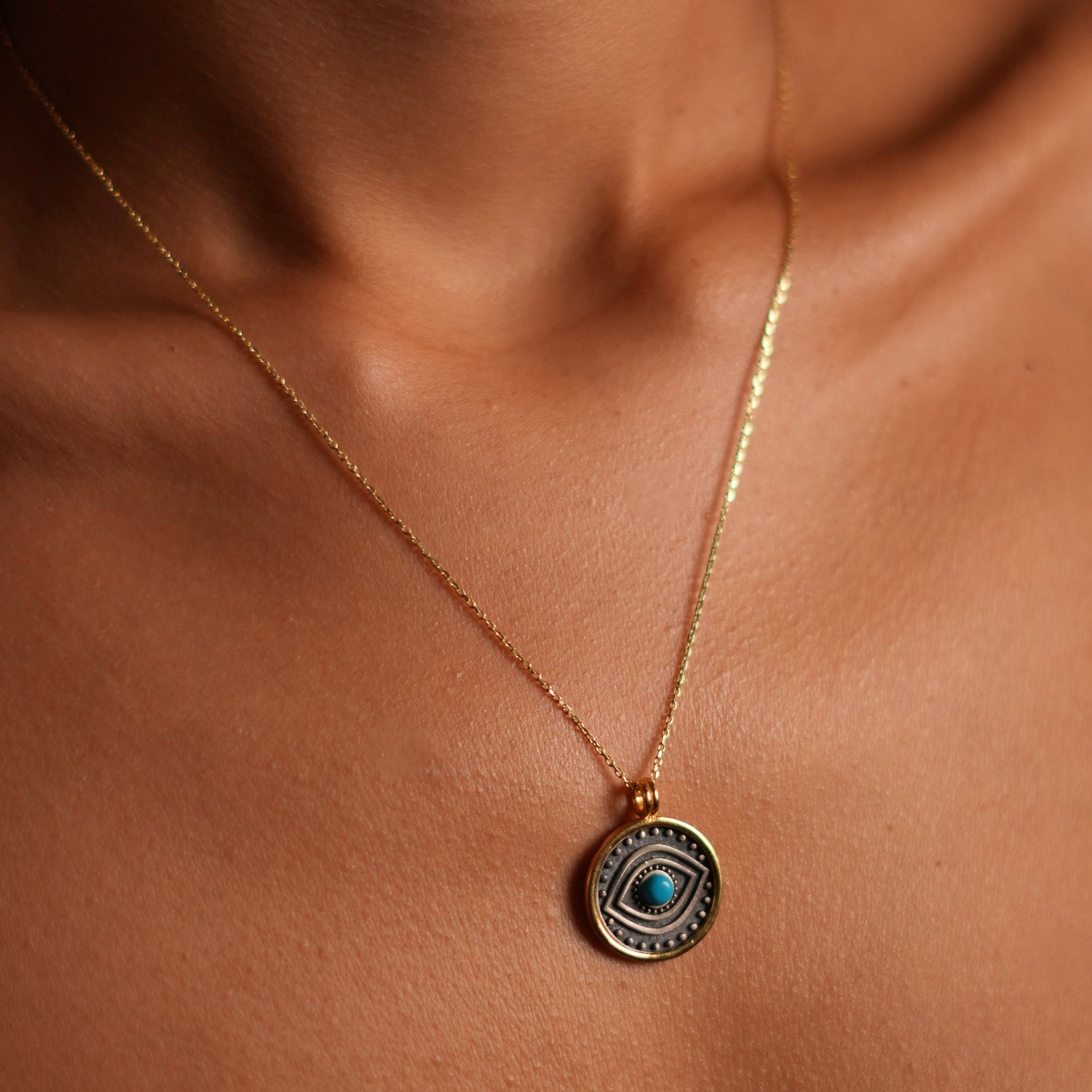 Refined sterling silver necklace with a turquoise evil eye pendant and gold-plated border, combining style with protective and tranquil symbolism.