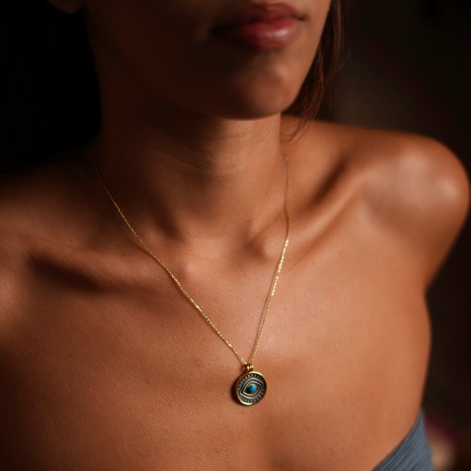 Charming sterling silver necklace with a turquoise evil eye pendant and gold-plated border, offering a blend of protection, serenity, and style.