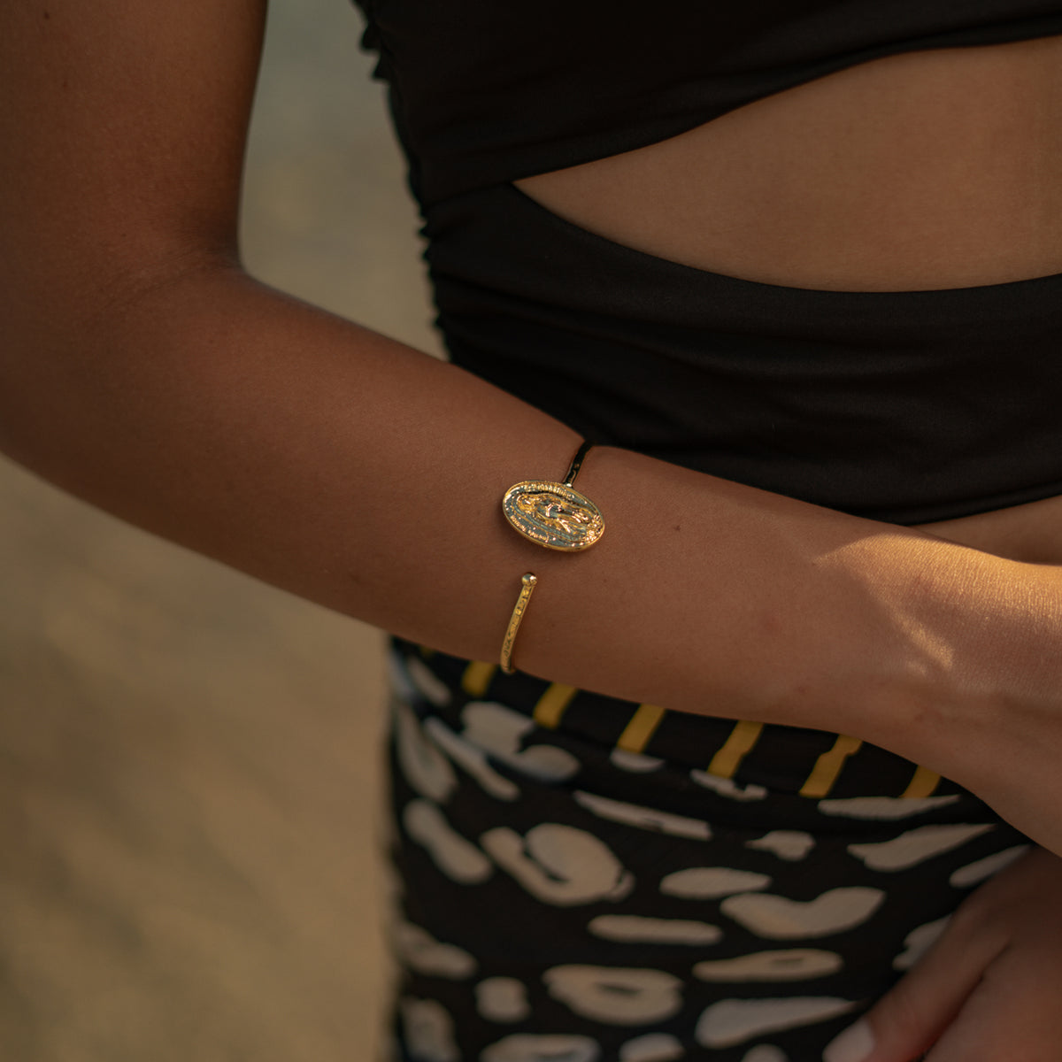 Close up of the Virgin Mary medallion gold cuff bracelet on the wrist
