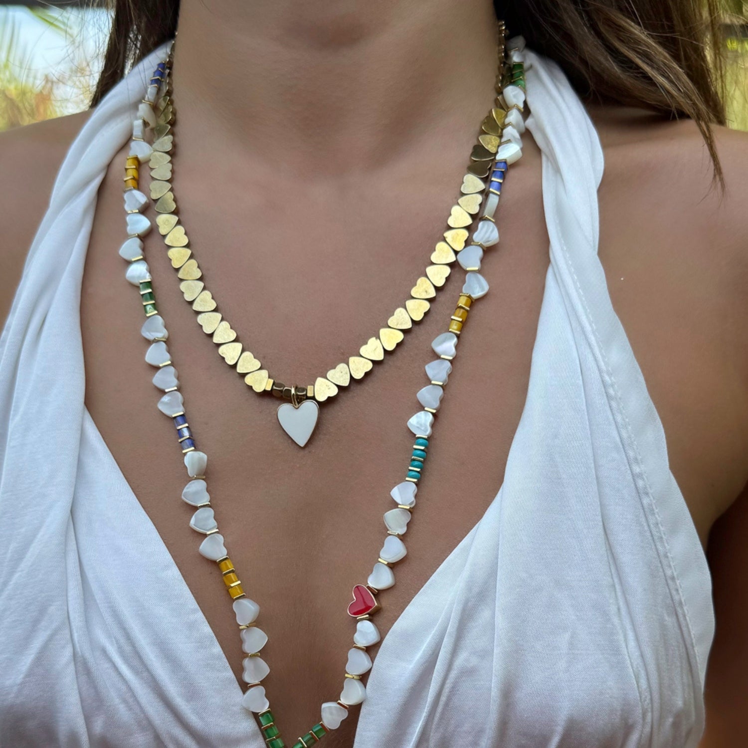 White enamel heart pendant on a gold-plated necklace with heart-shaped hematite stone beads