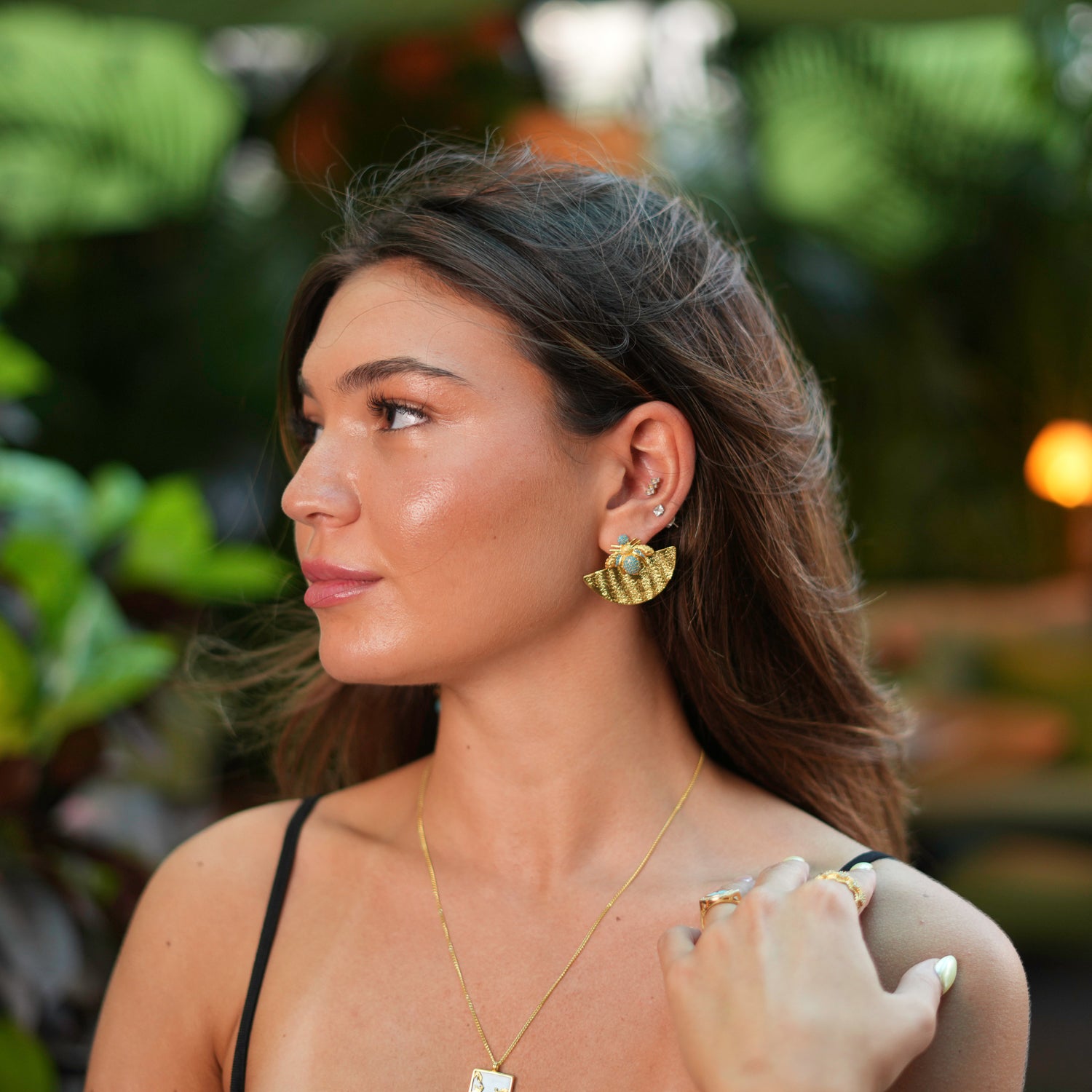 Luxurious gold earrings featuring a half-moon shape with turquoise accents and a honey bee motif, crafted to add a touch of abundance to your look.
