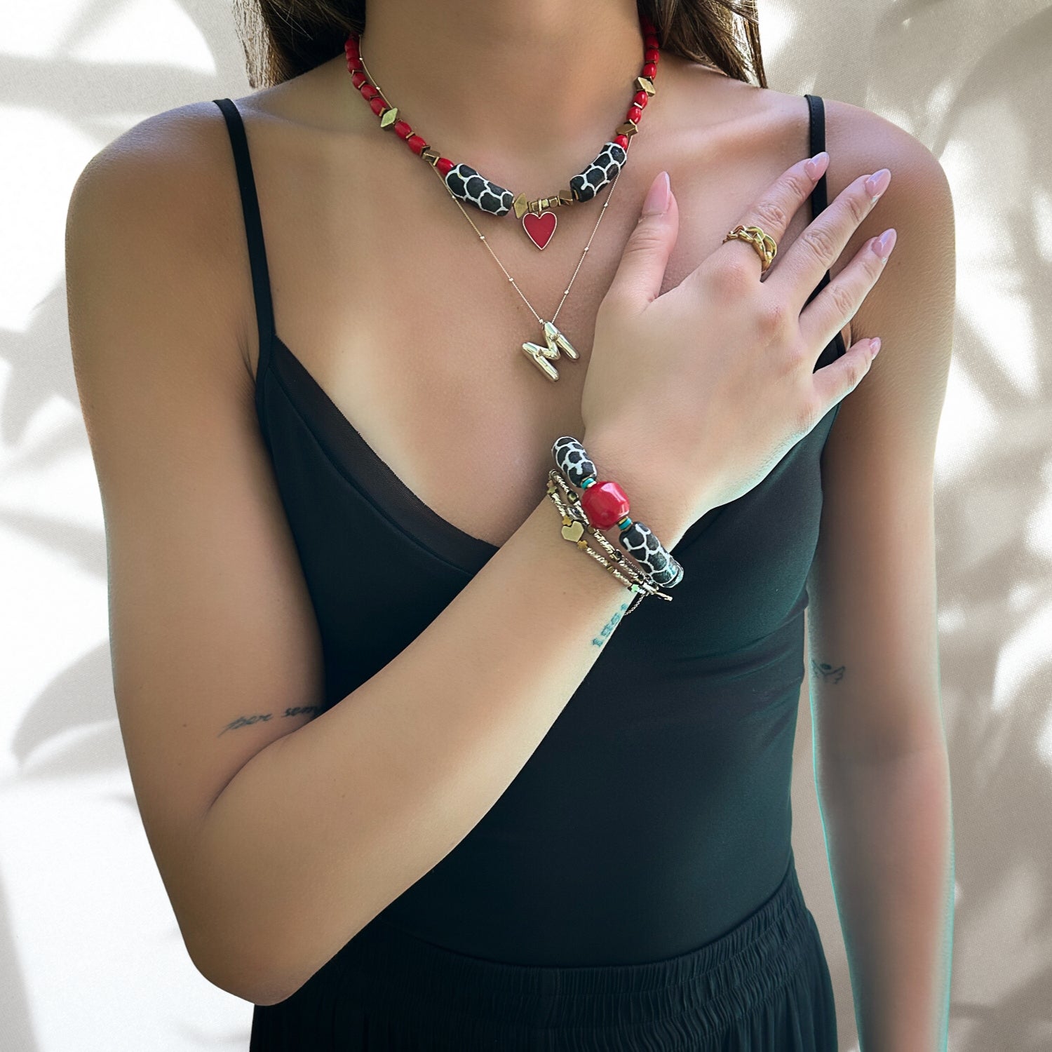 Close-up shot of a model wearing the African Zebra Red Bracelet, highlighting the intricate details of the zebra tube beads and red coral bead.