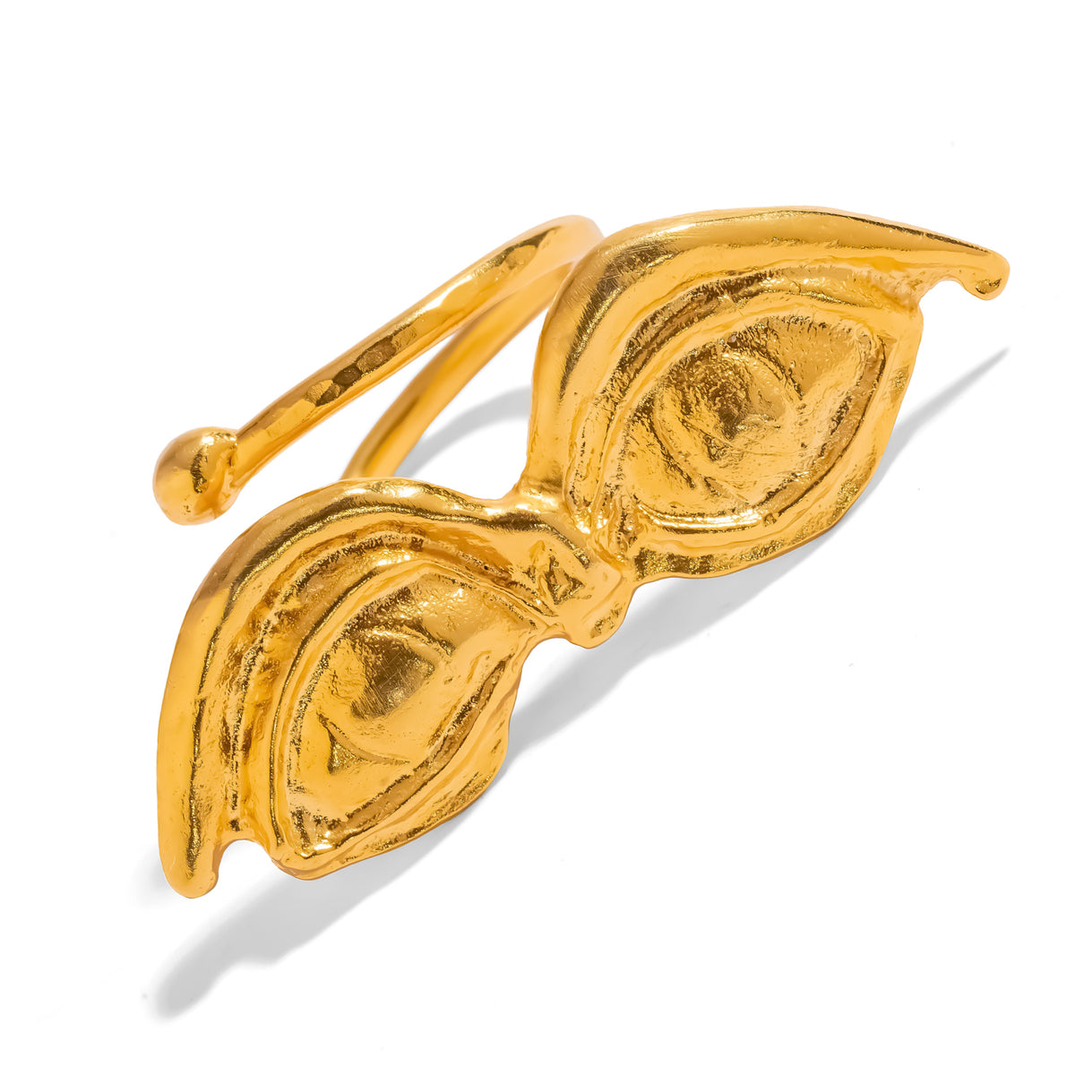 Three quarter view of the sculpted gold eyes, each iris and lid worked in relief