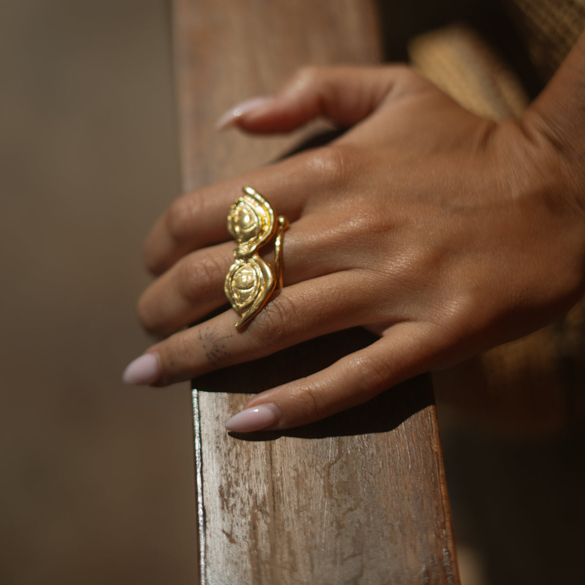 The All Seeing Eyes gold ring worn along the finger, the two eyes stacked one above the other