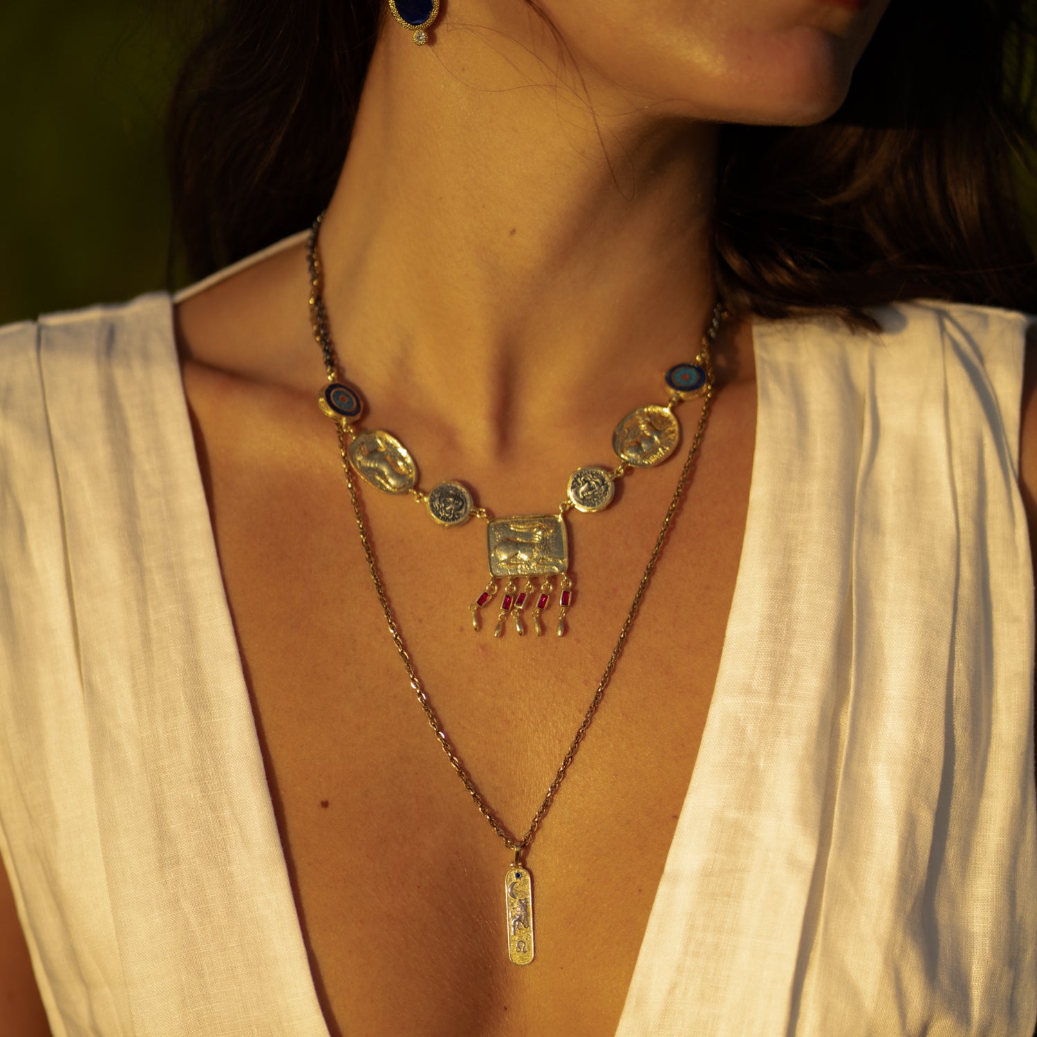 Amulet Gathering Evil Eye & Ruby Fringe Two Tone Necklace worn close up, gold plaque and fringe resting at the collarbone