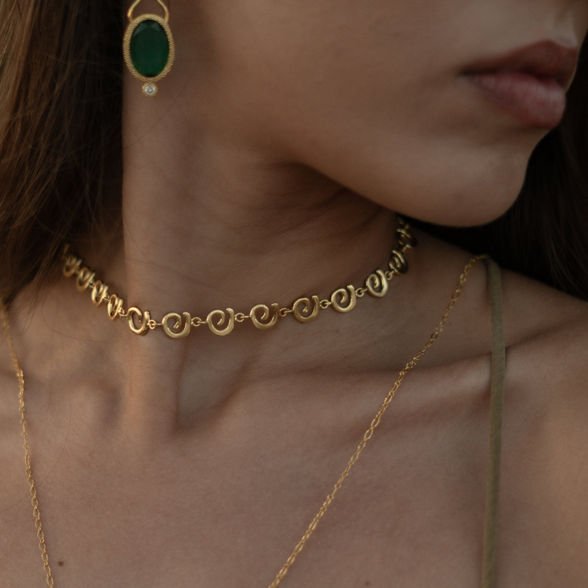Ancient Rhythm Spiral Gold Link Chain Necklace worn close at the neck with green jade drop earrings