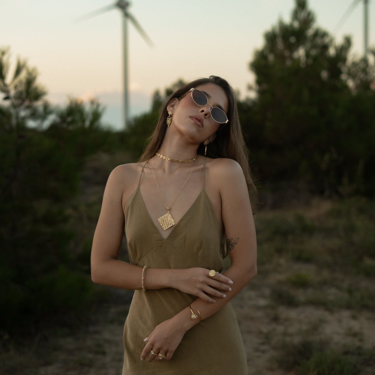 Full length view of a model wearing the Ancient Rhythm Spiral Gold Link Chain Necklace with layered Ebru Jewelry gold pieces