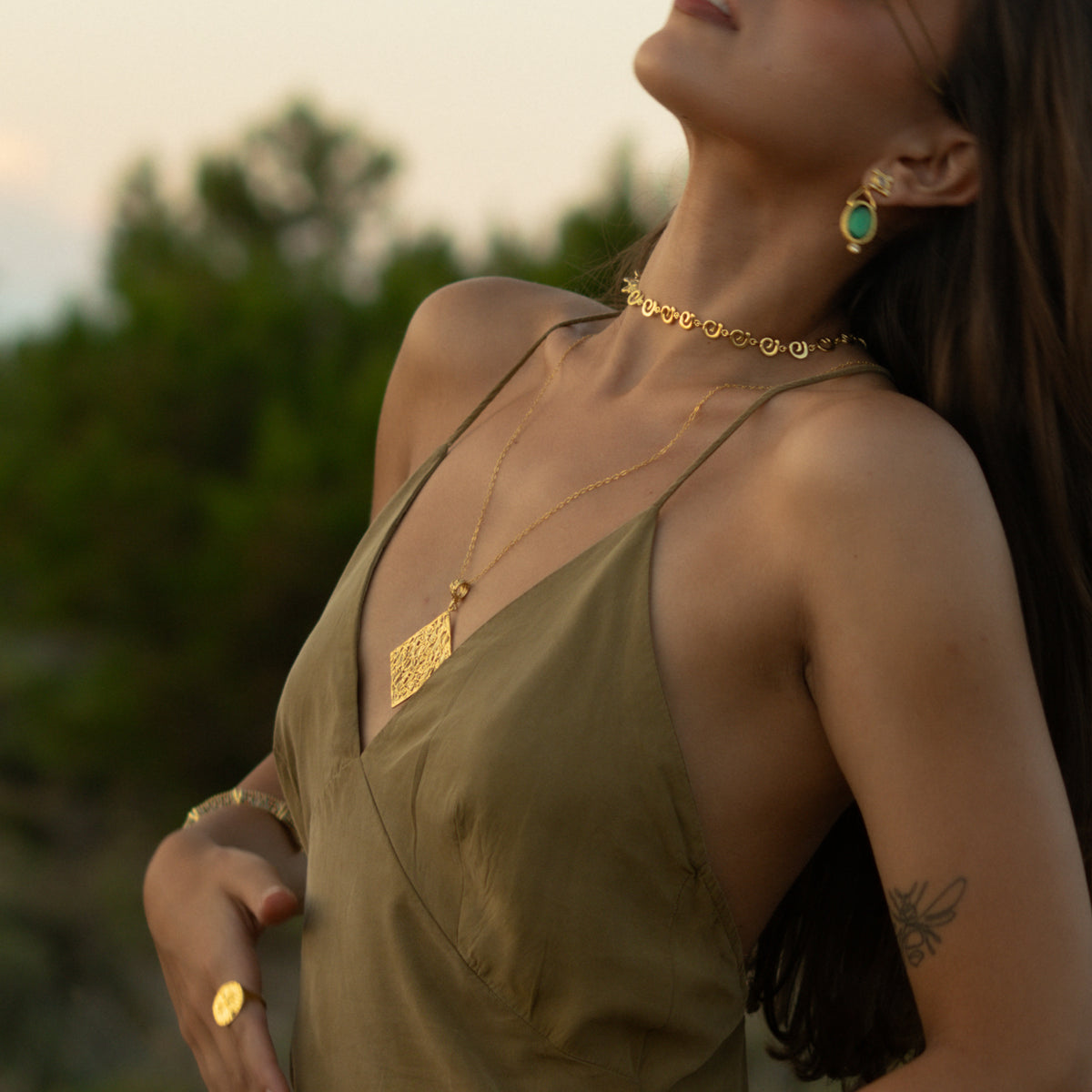 Ancient Rhythm Spiral Gold Link Chain Necklace worn at the base of the neck, the spiral links catching the evening light