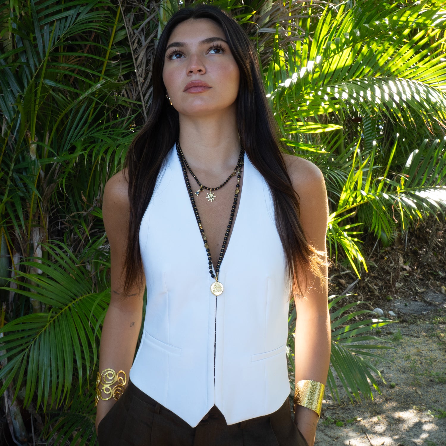 Model wearing Be Free onyx beaded long necklace layered with Vacation Mode sun necklace