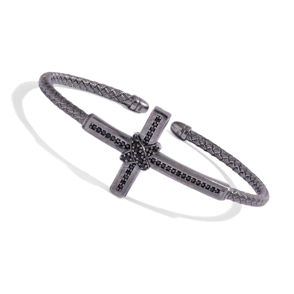 Angled view of the oxidized woven silver cuff showing the black zircon cross and capped open ends