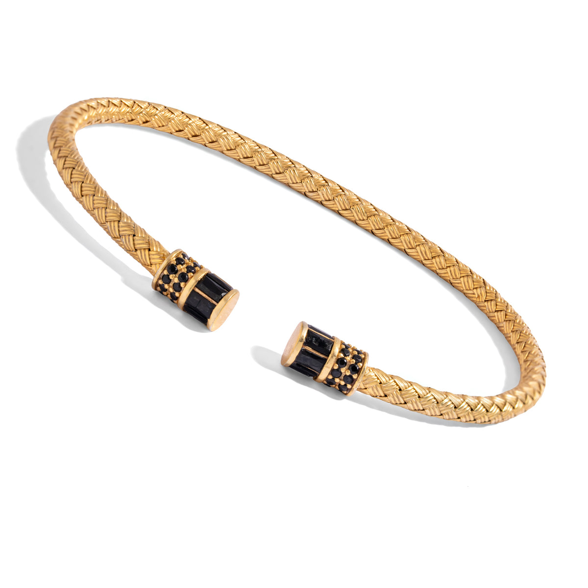Angled view of the woven gold vermeil cuff showing the black barrel end caps and rows of tiny black stones