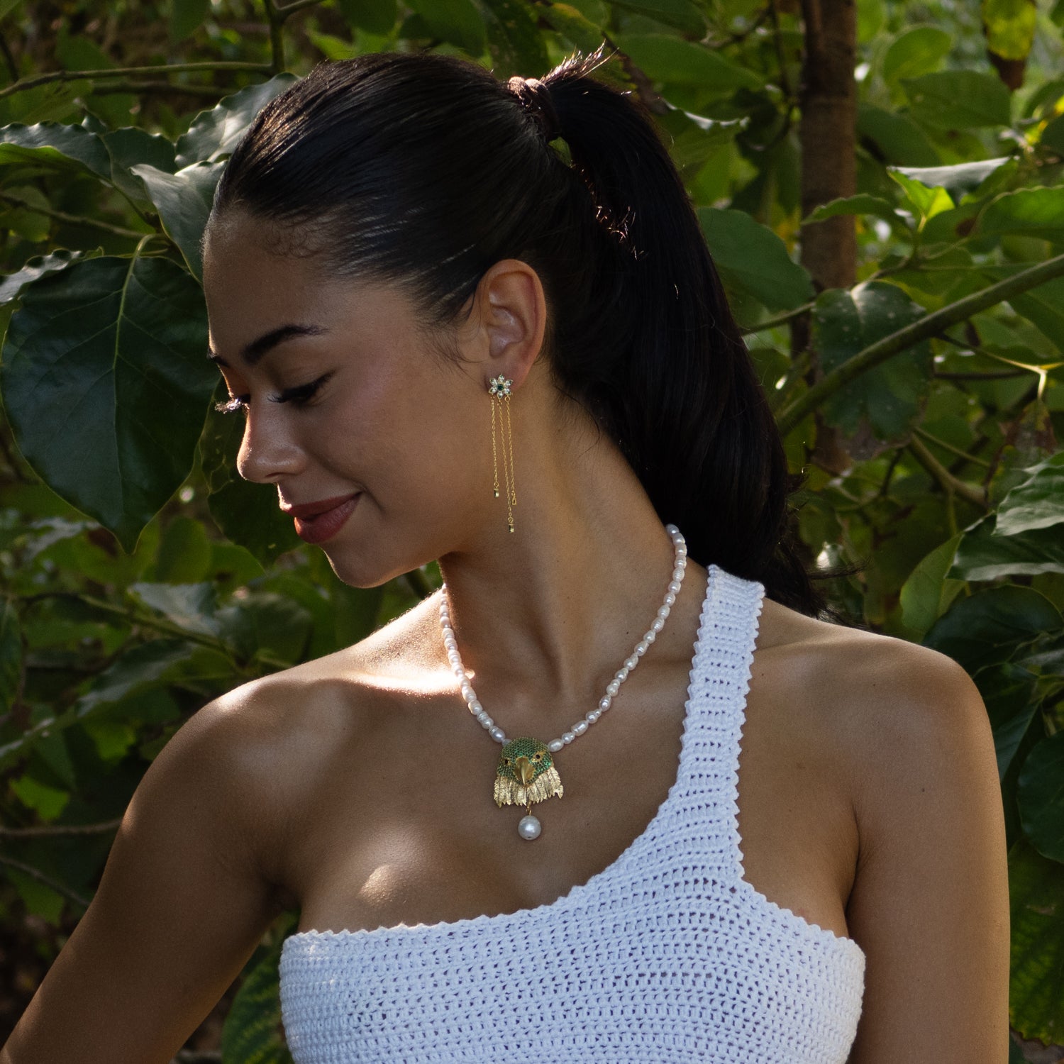 Blossom Glow earrings in 18k gold vermeil with green emerald drop stones, floral-inspired design, and delicate gold chain details.