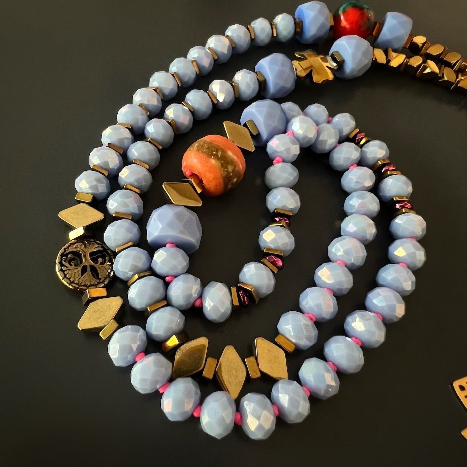 Blue Magic Gold Elephant Necklace, a handmade and meaningful accessory with a combination of blue crystal beads, gold-colored hematite stone beads, and the elephant pendant.