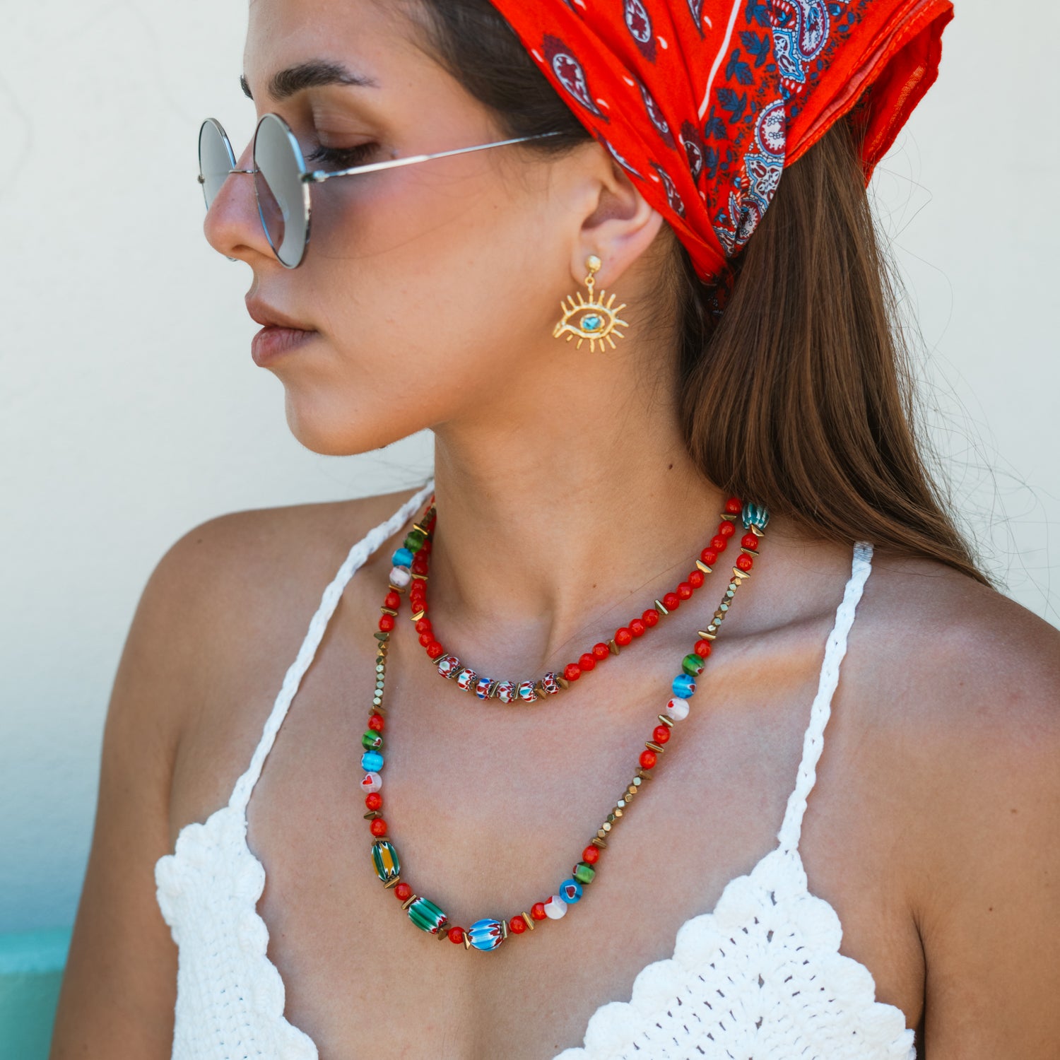 Model in red paisley headscarf and sunglasses wearing the Carnelian Fire Energy Beaded Choker, a handmade colorful beaded choker layered with a longer beaded necklace