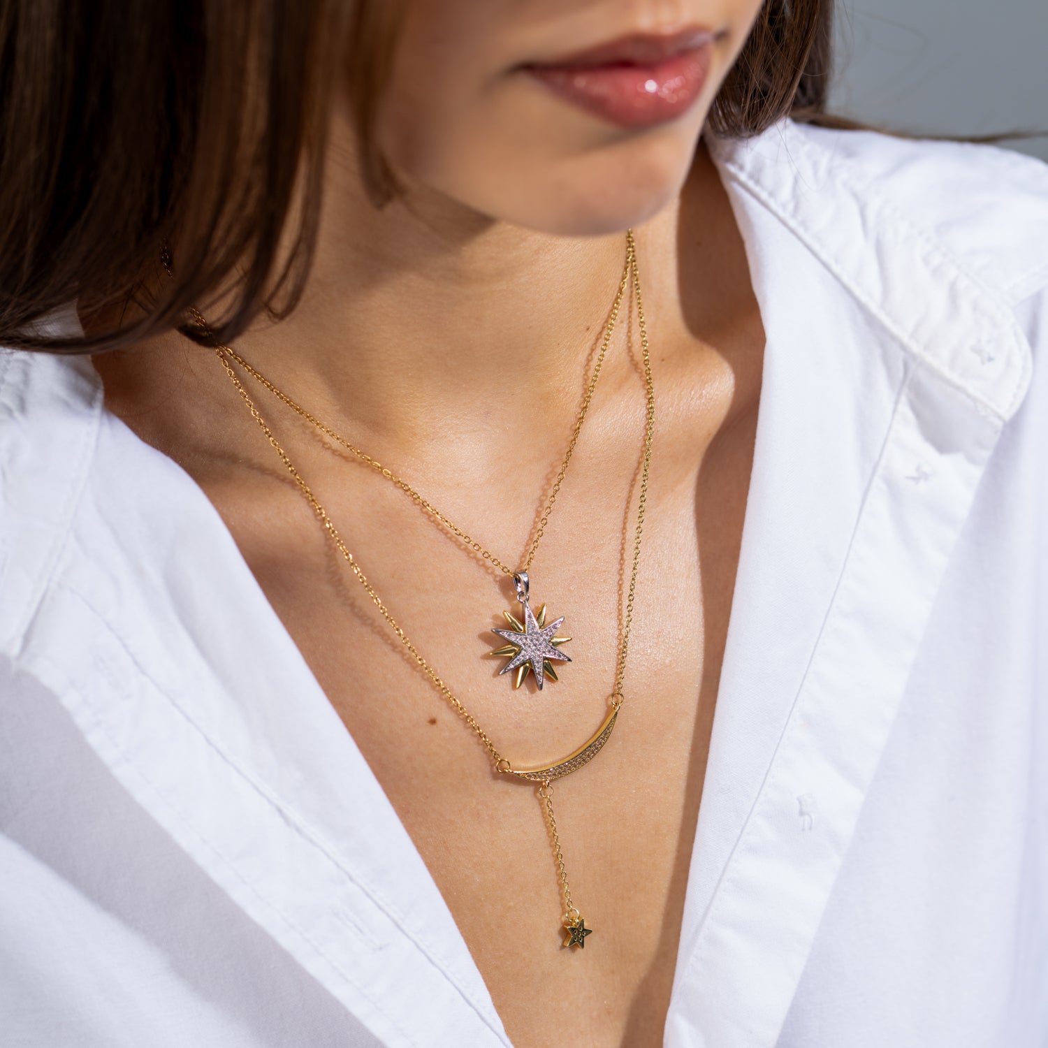 Celestial gold Y-drop necklace with CZ-studded crescent moon and dangling star pendant on an 18k gold-plated chain.

