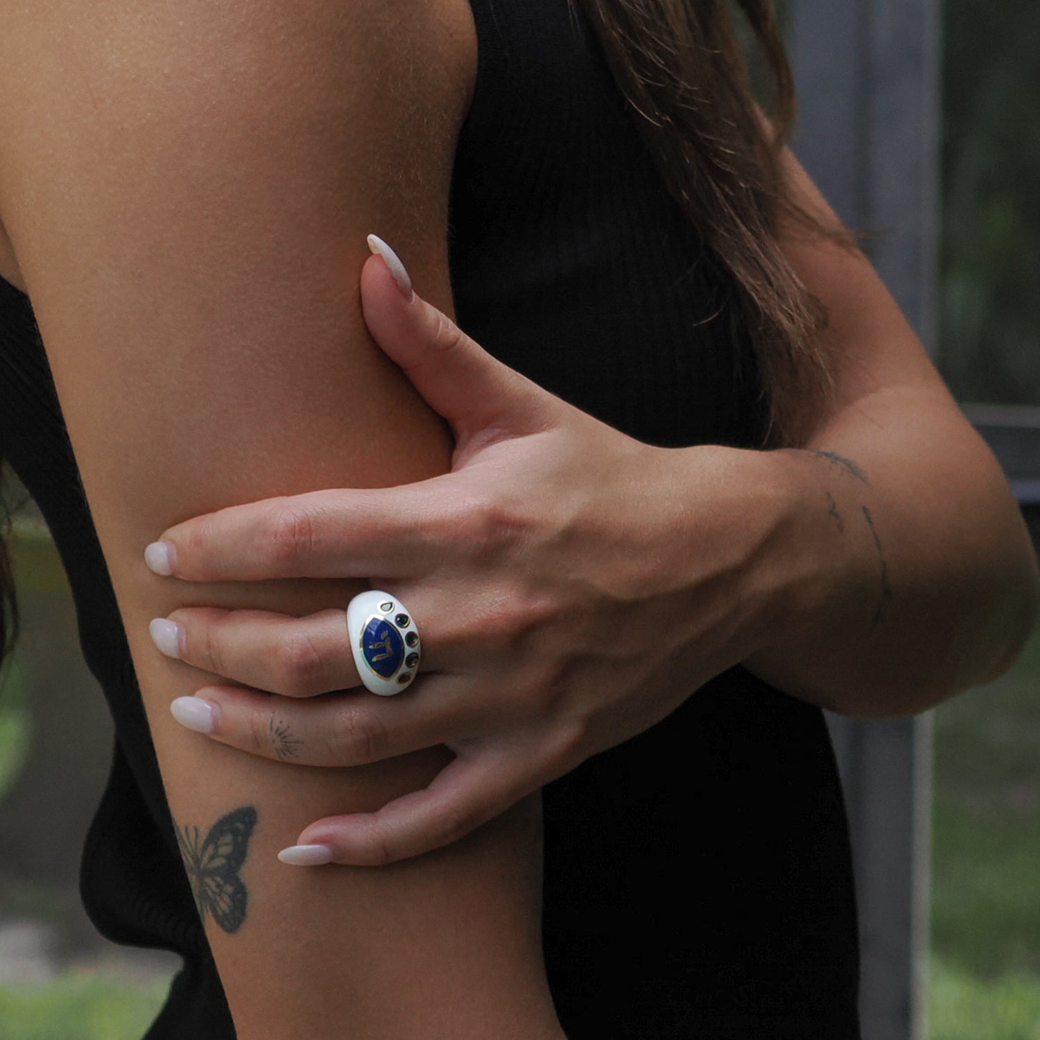 Chai Symbol & Emerald Eye Adjustable Ring showcasing green emerald details on a chic blue enamel surface.