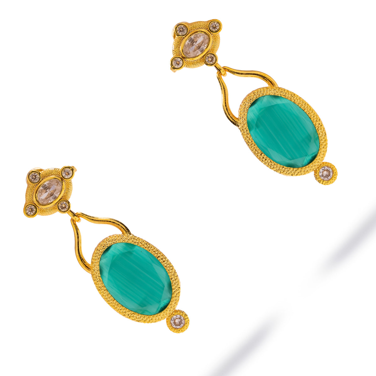 Cleopatra Emerald Cat Eye Gold Drop Earrings laid diagonally on white, green cat eye stones with clear zircon accents