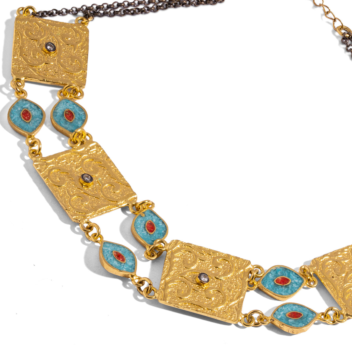 Close detail of the engraved gold scroll plaques and marquise turquoise and coral inlay evil eye links