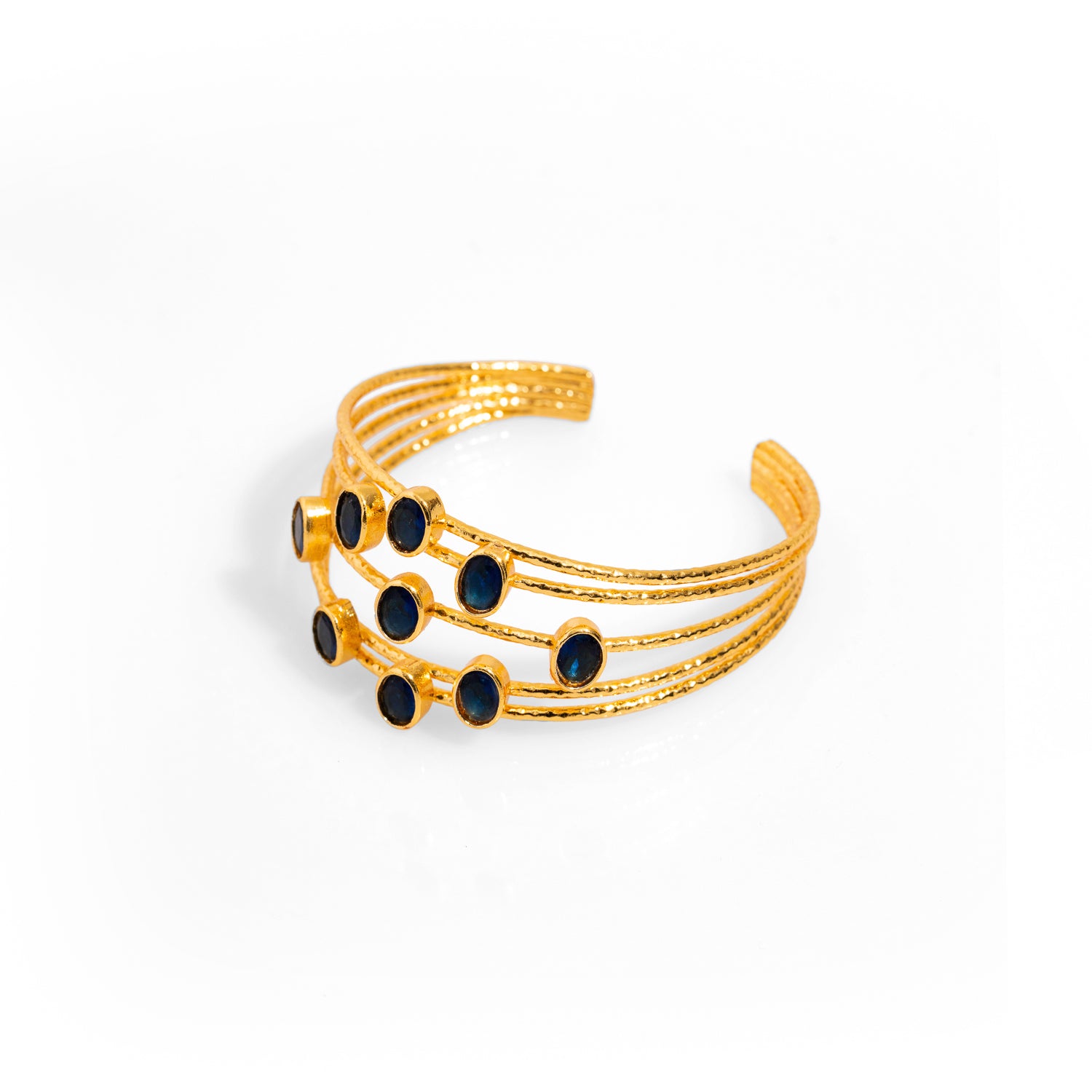 Gold and sapphire chunky cuff bracelet with 24k plating, featuring a bold design with five gold wires, adjustable for comfort.
