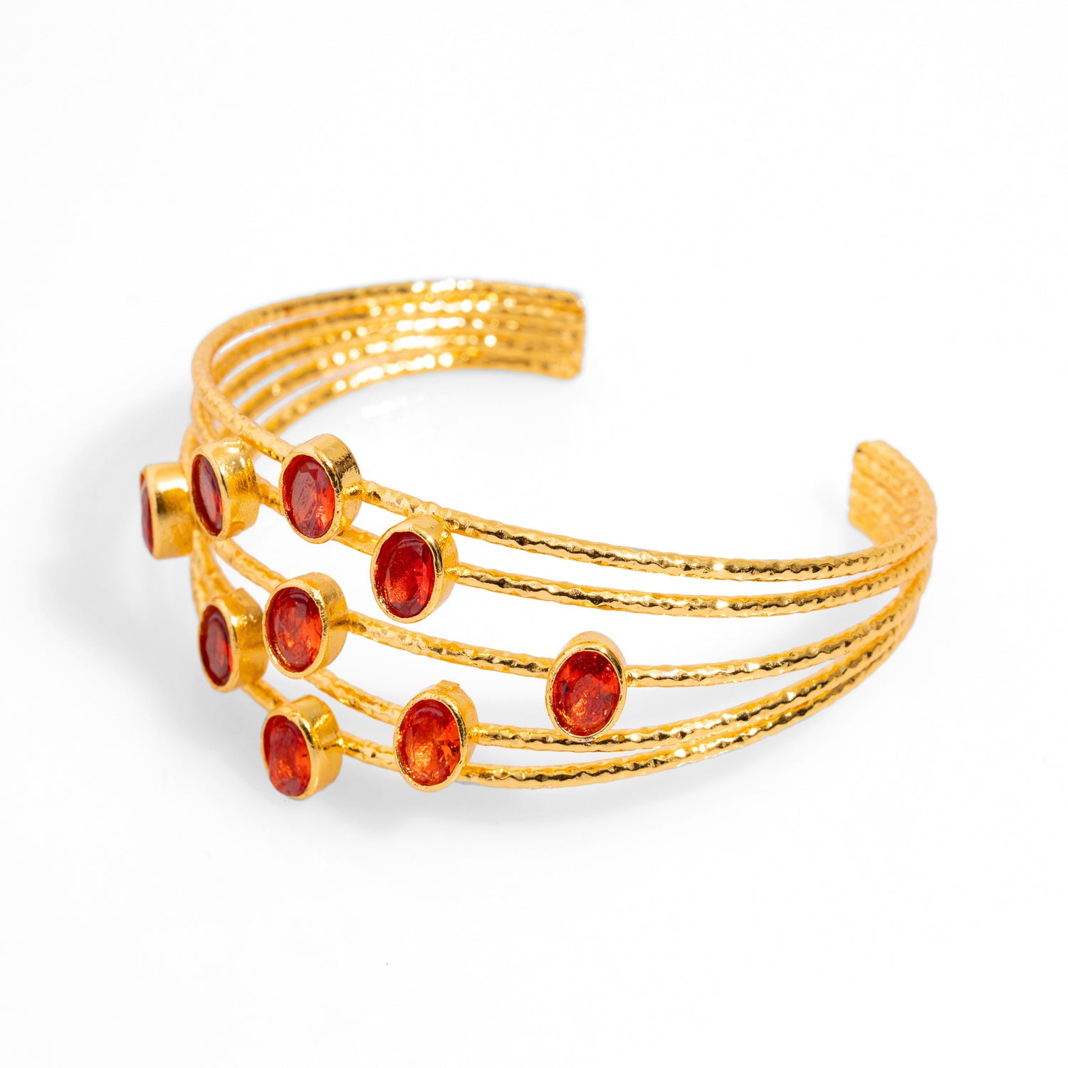 Chunky cuff bracelet with 24k gold plating and five thin gold wires, adorned with oval carnelian stones, adjustable size.
