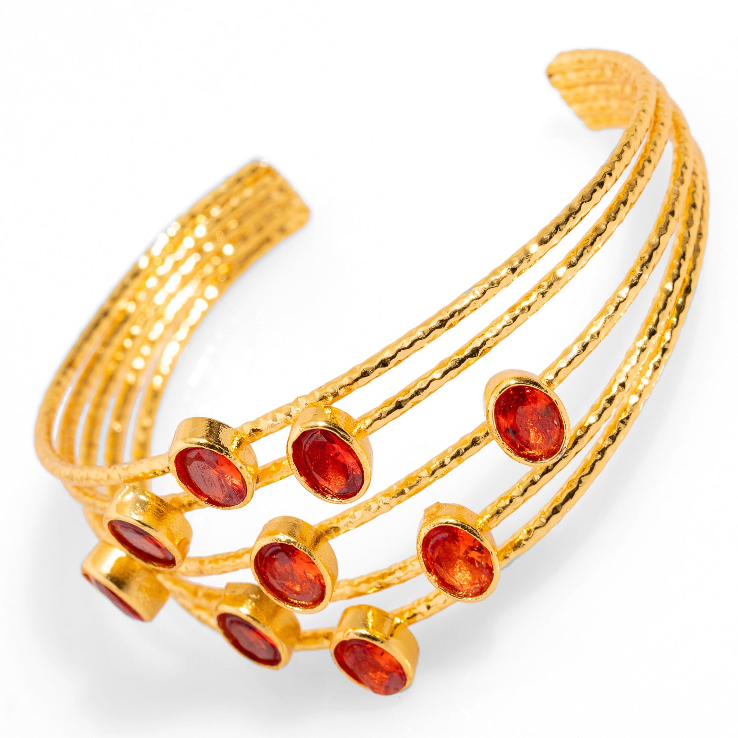 Stylish 24k gold-plated cuff bracelet with five intertwined gold wires and carnelian stones, adjustable to fit various wrist sizes.
