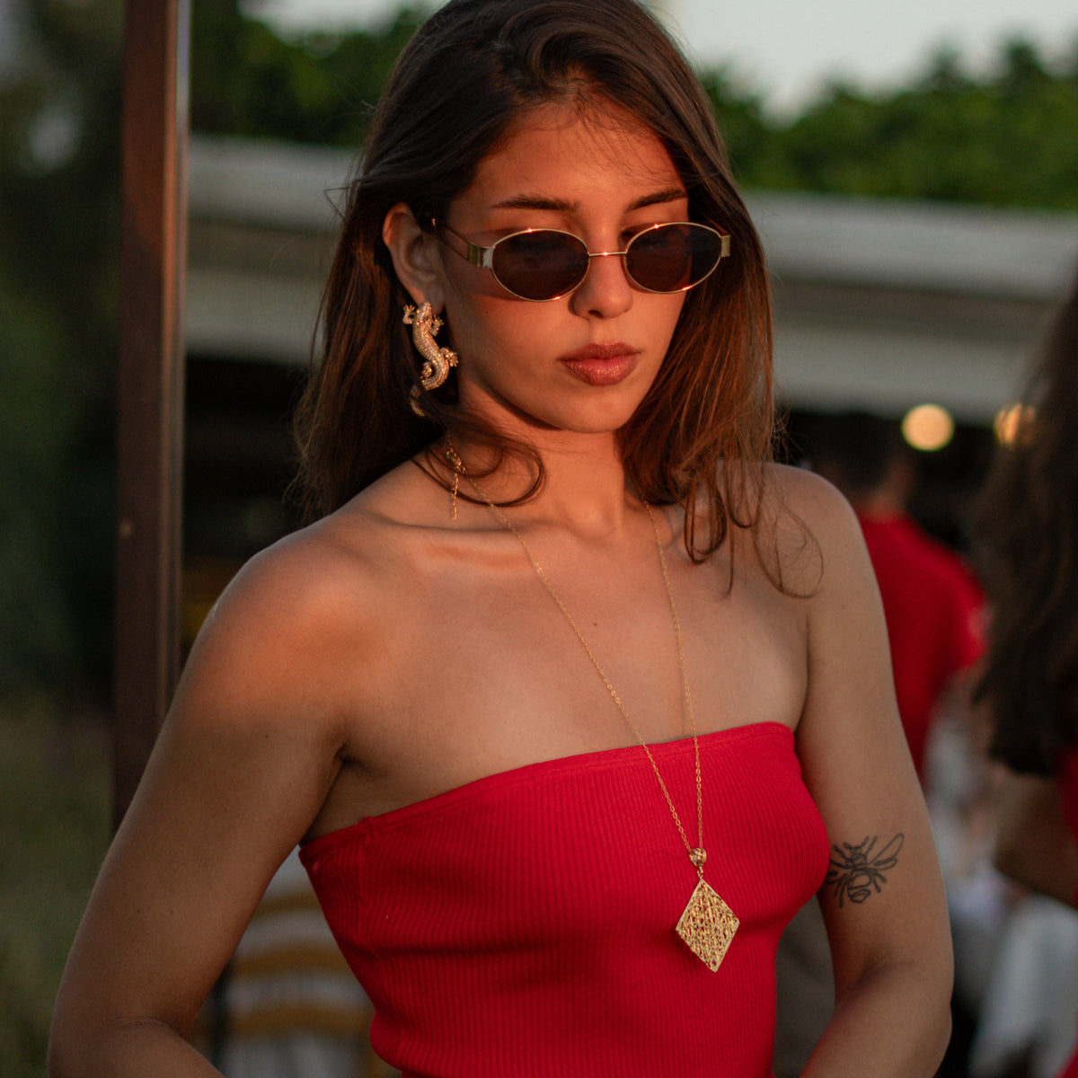 Woman in a red dress at sunset wearing the Cleopatra Golden Lace Long Pendant Necklace
