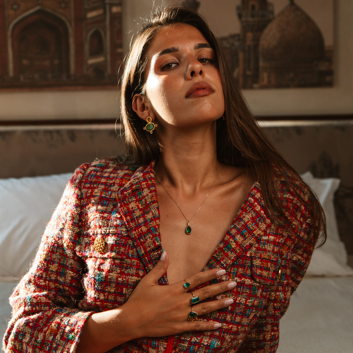 Model in a tweed jacket wearing the Cleopatra Green Cat Eye gold statement stud earrings and green stone jewelry