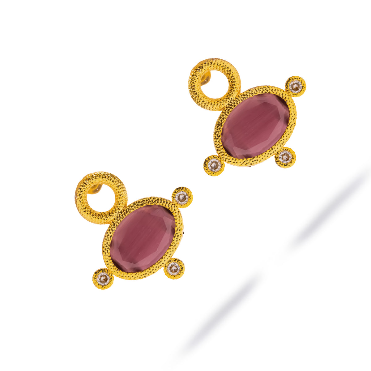 Cleopatra Mocha Cat Eye Gold Statement Earrings laid diagonally on white, oval cat eye stones in rosy mauve