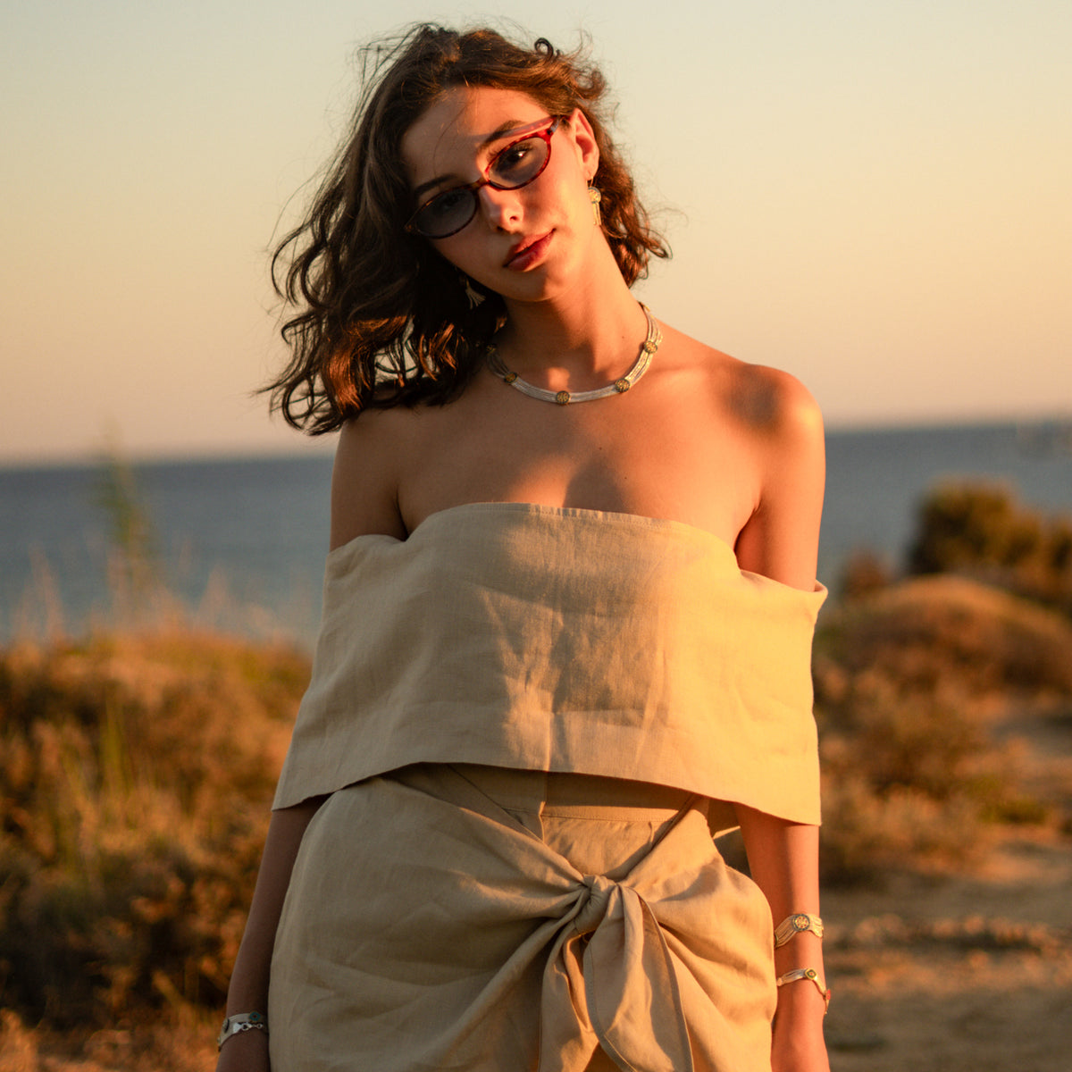 Model in a linen strapless top wearing the Cleopatra Mystic Vintage Style Two Tone Statement Necklace at sunset