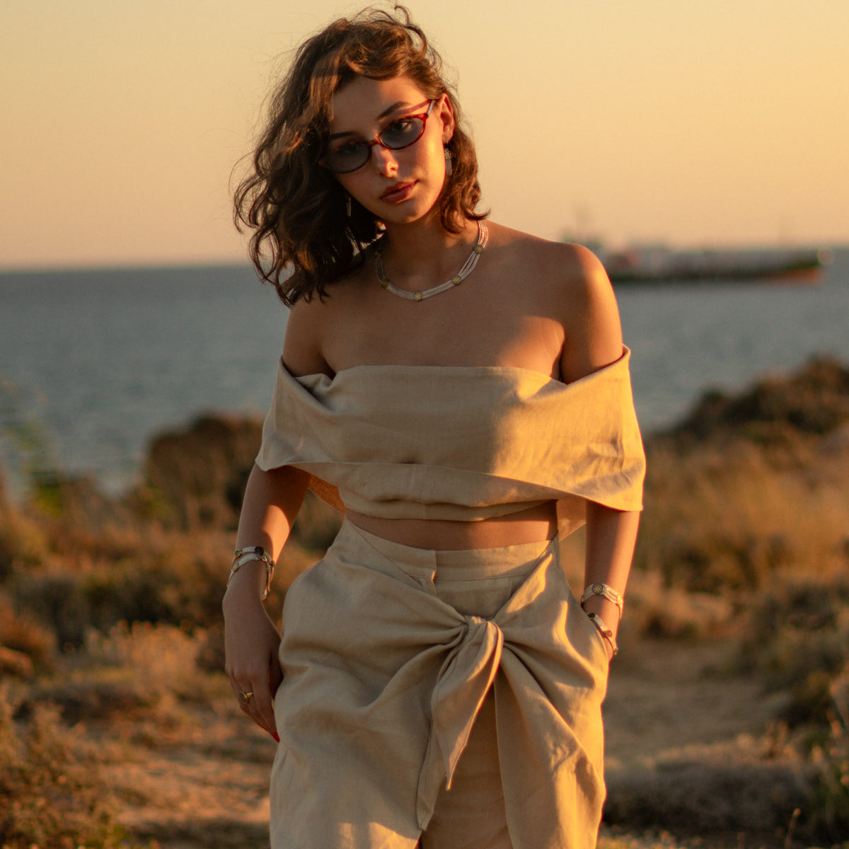Full length view of the model at the coast wearing the Cleopatra Mystic two tone statement necklace