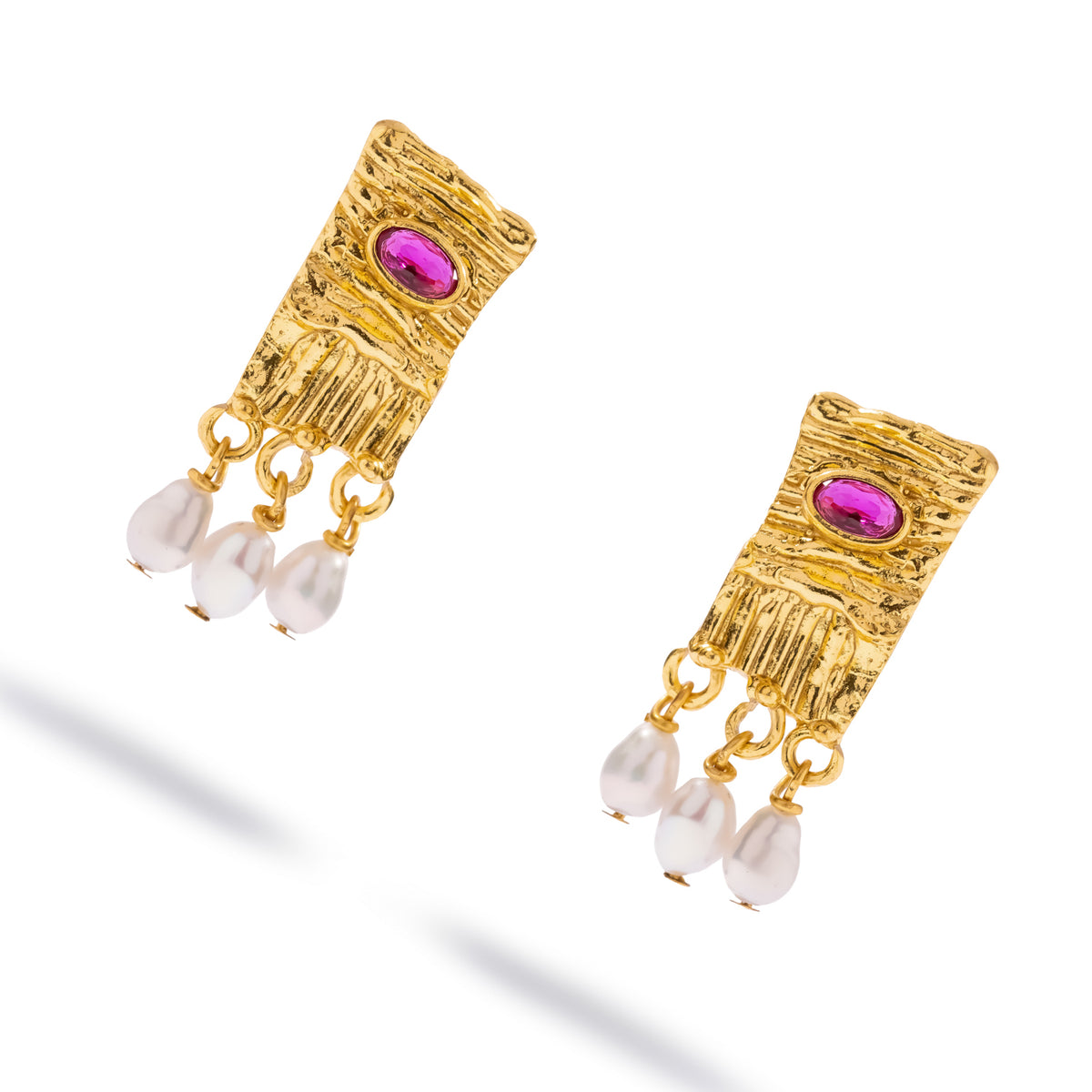 Angled view of the Cleopatra Ruby & Pearl earrings showing the rippled gold surface