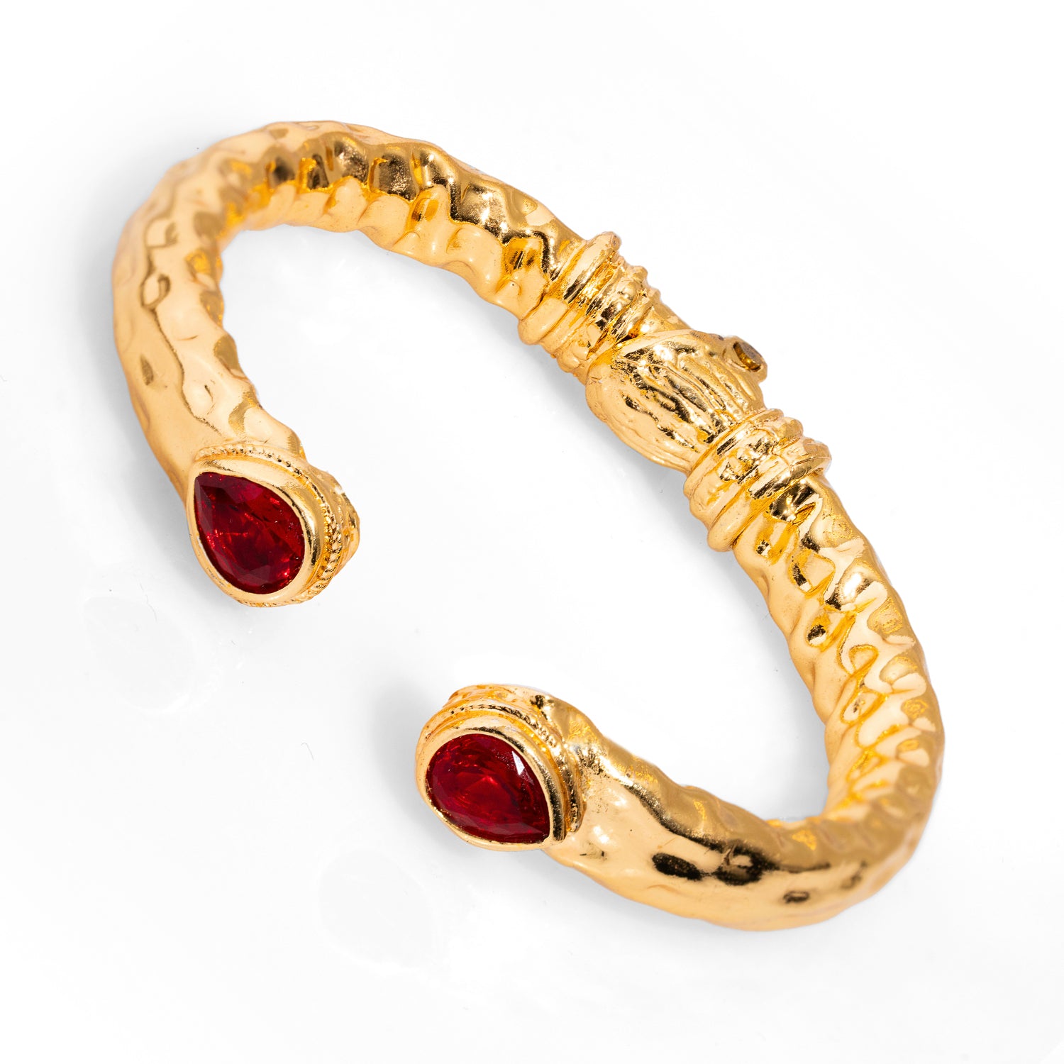 Striking 24k gold-plated brass cuff bracelet adorned with teardrop ruby stones, capturing the mystic elegance and royalty of Cleopatra.
