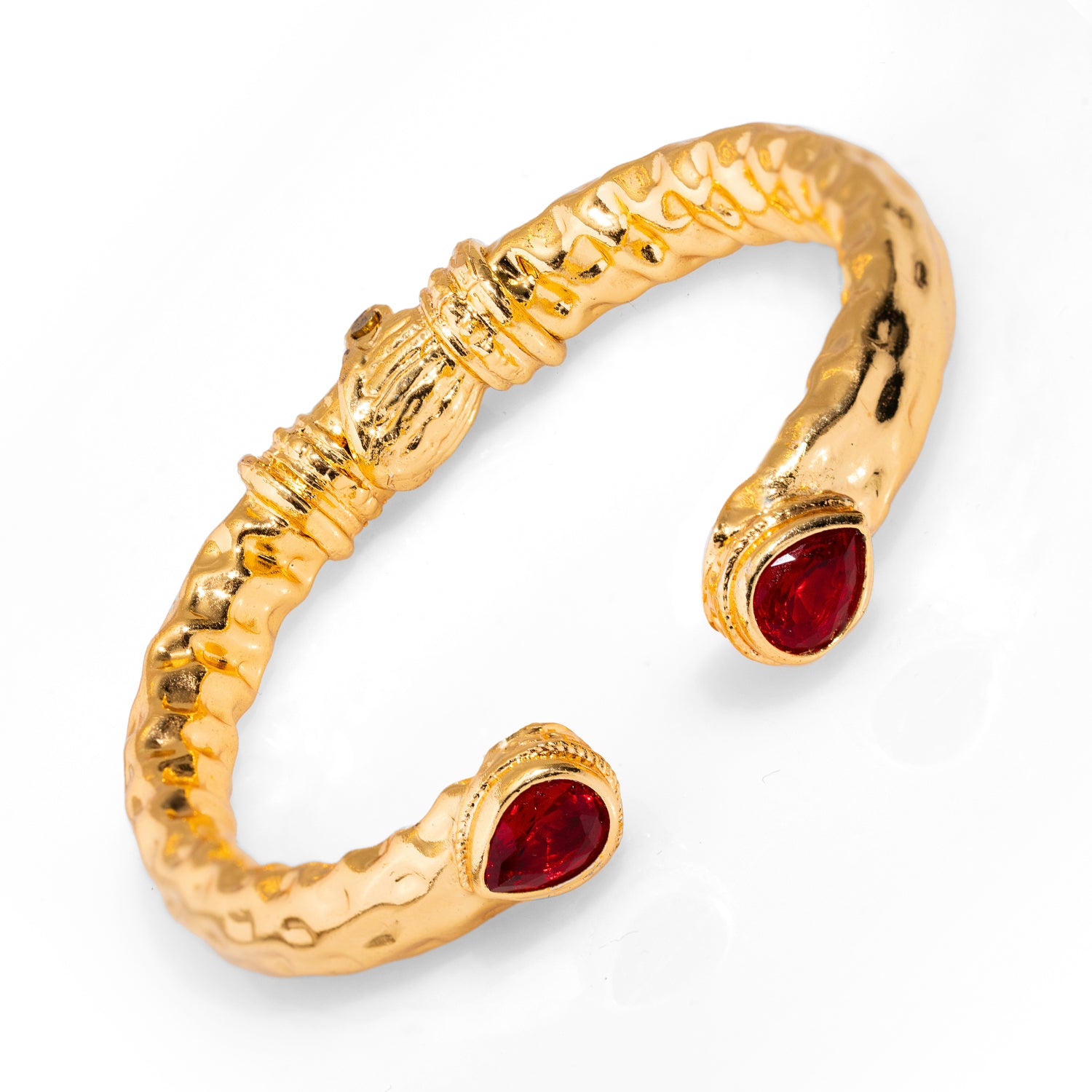 Statement-making gold cuff bracelet adorned with teardrop-shaped ruby stones, reflecting the mystique and luxury associated with Cleopatra.
