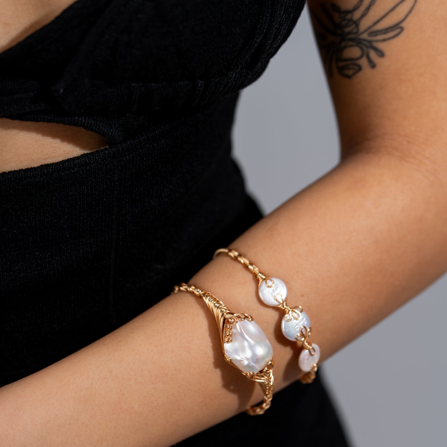Cleopatra’s Treasure open cuff bracelet with a large baroque pearl and small gold beads on an adjustable 18K gold-plated band.
​


