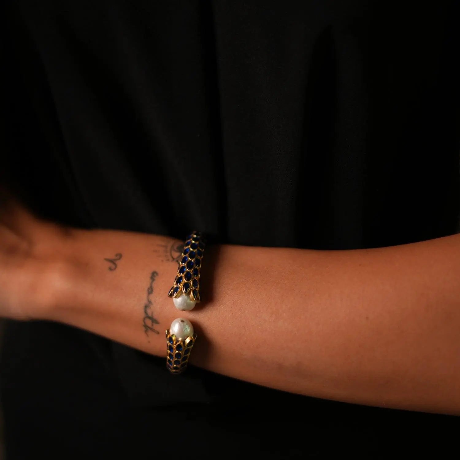 24k gold plated chunky cuff bracelet with blue sapphire stones and luminous pearls for a glamorous finish.