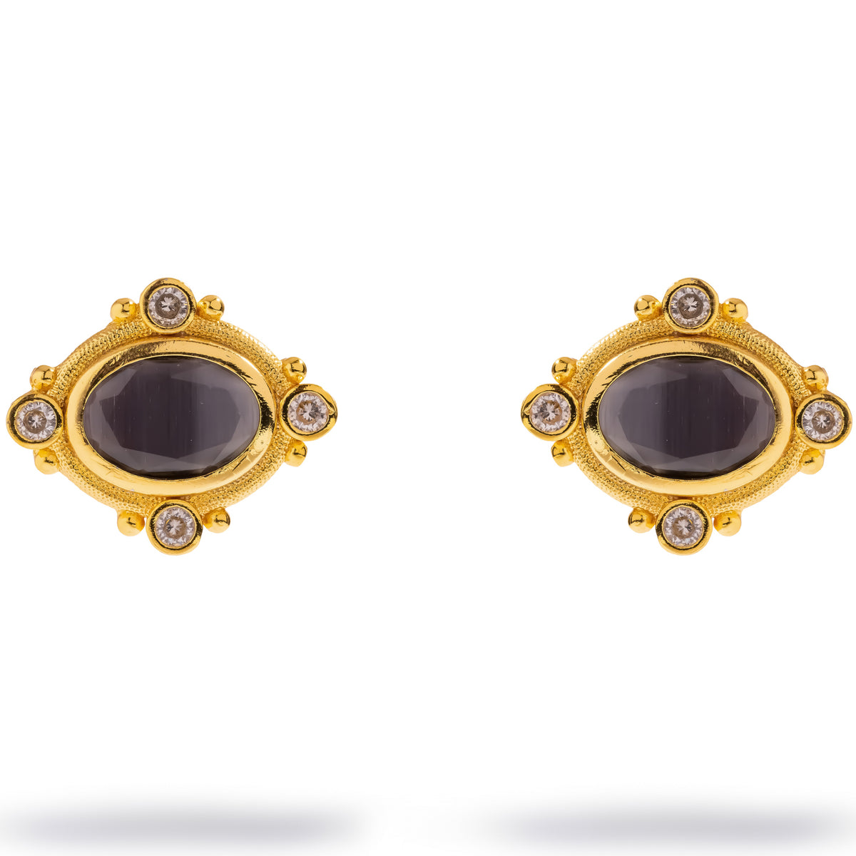 Gold stud earrings with an oval black cat's eye stone framed by four clear zircon accents