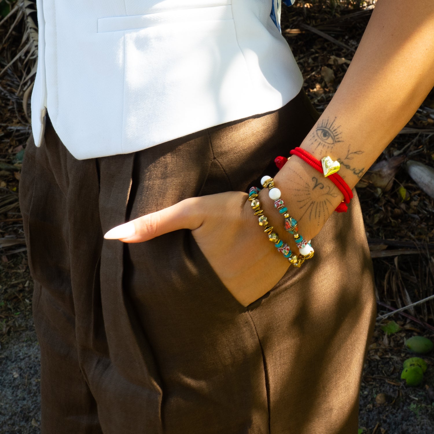 Close-up of Coastal Bohemia boho bracelet duo on wrist featuring Tibetan inlay bead and white jade beads with gold hematite accents