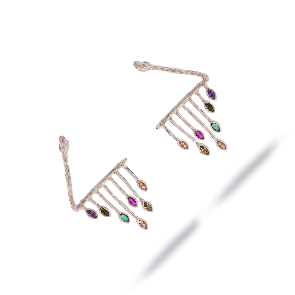 Color Rhythm silver statement earrings laid diagonally, marquise gemstones fanned along the bar