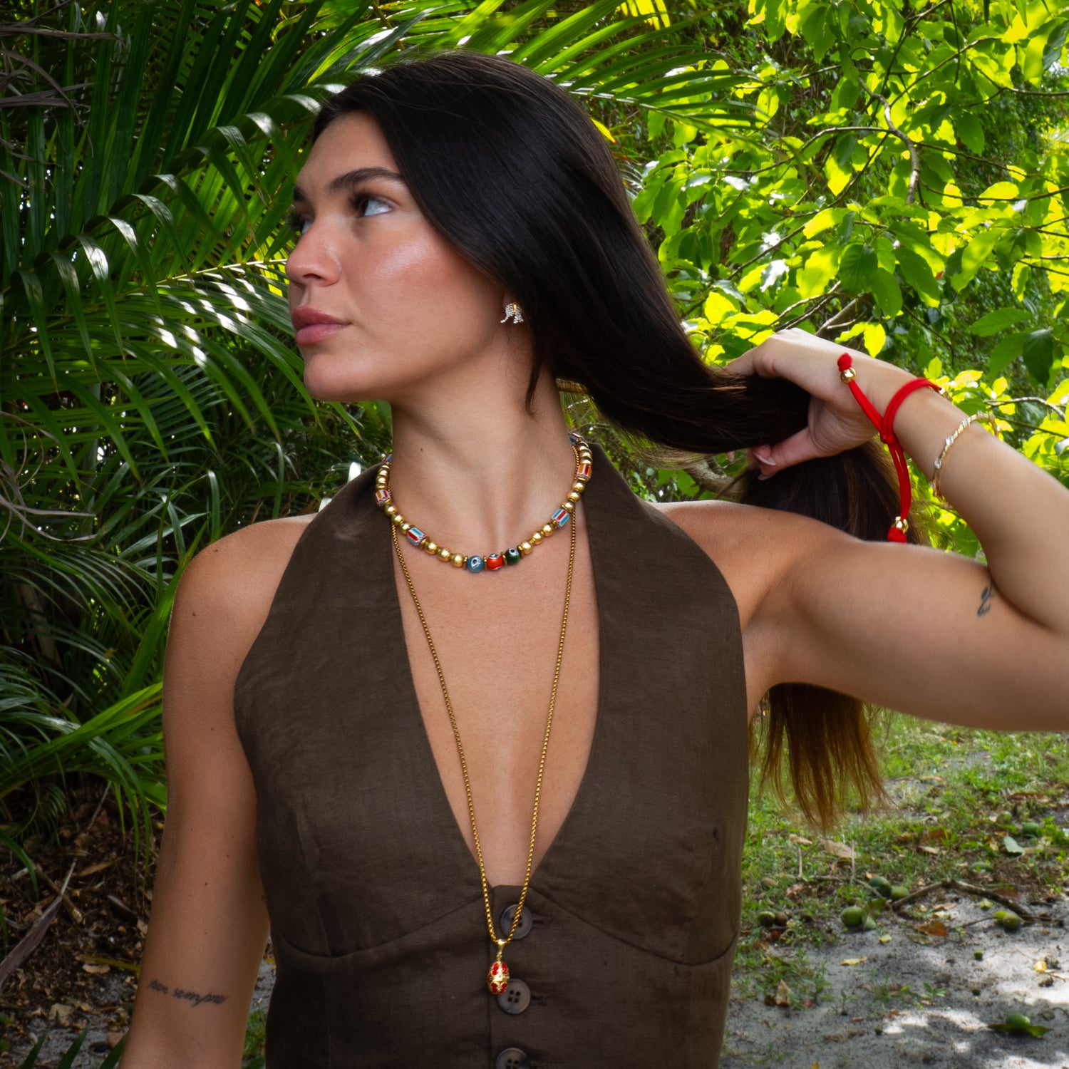 Summer Love Sacred Heart beaded gold necklace layered with gold chain necklaces on model, colorful summer jewelry style