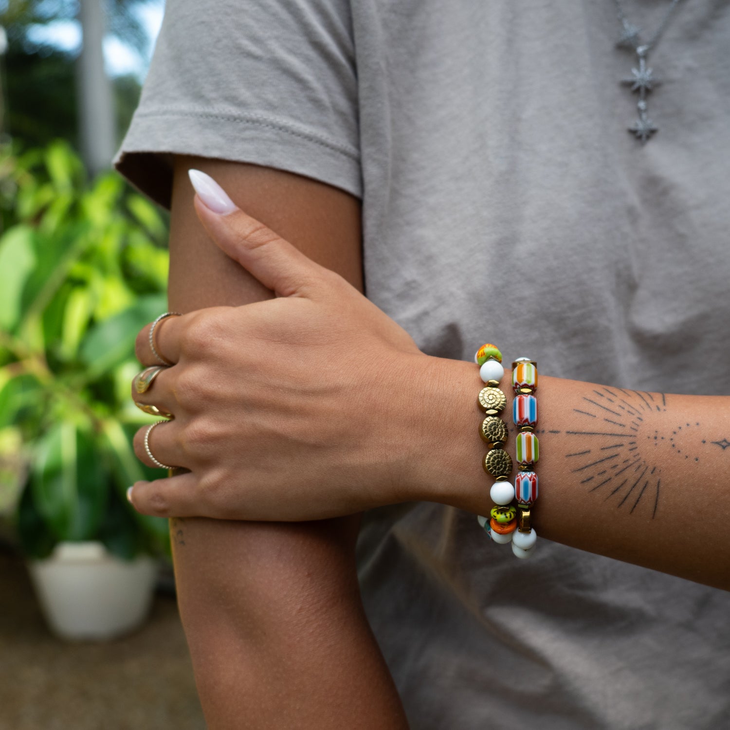 Person wearing a colorful beaded bracelet on a blurred natural background