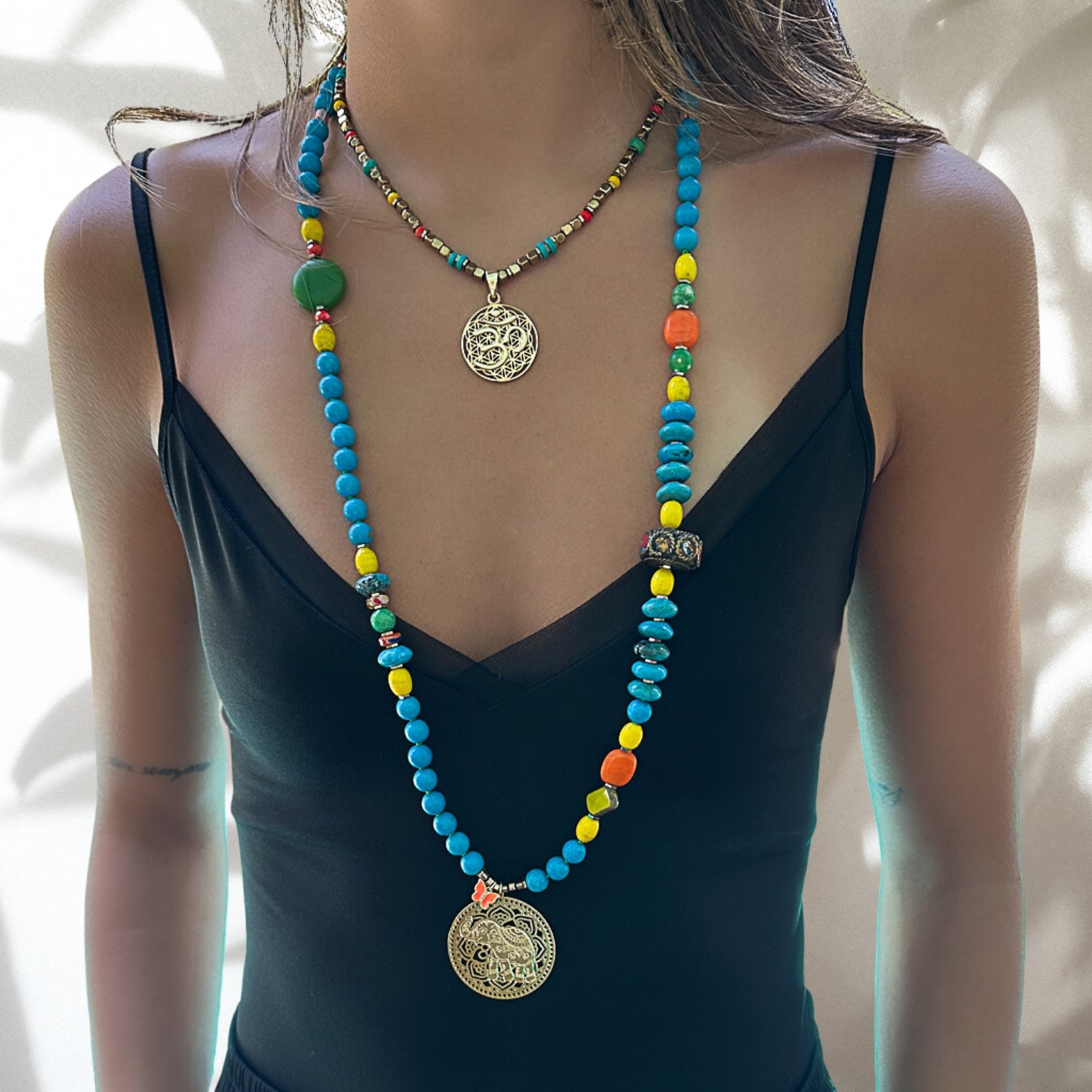 Our model beautifully showcases the Colorful Therapy Elephant Turquoise Necklace, highlighting its captivating turquoise beads, colorful crystals, and intricate elephant pendant.
