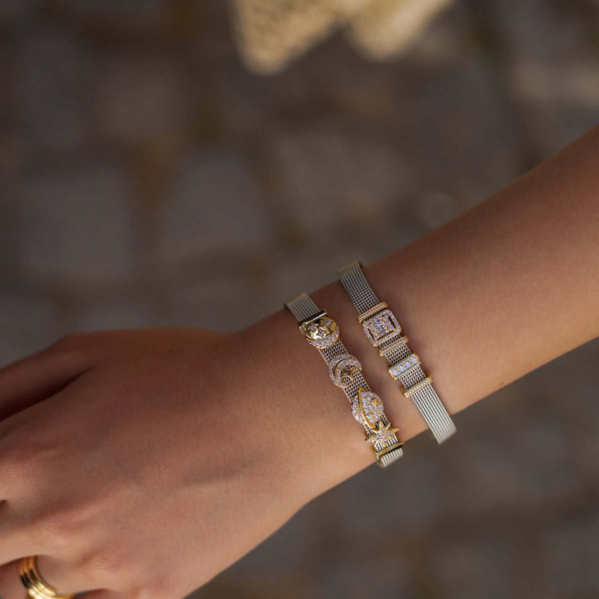 Close view of the wrist with the Cosmic Guidance celestial charm bracelet and a baguette charm bracelet