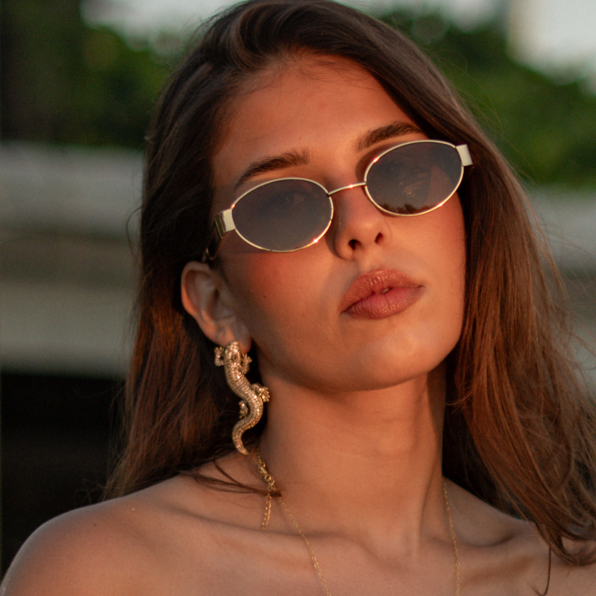 Close portrait of a woman wearing the Crocodile Pave Zircon Gold Statement Earring curving along the ear