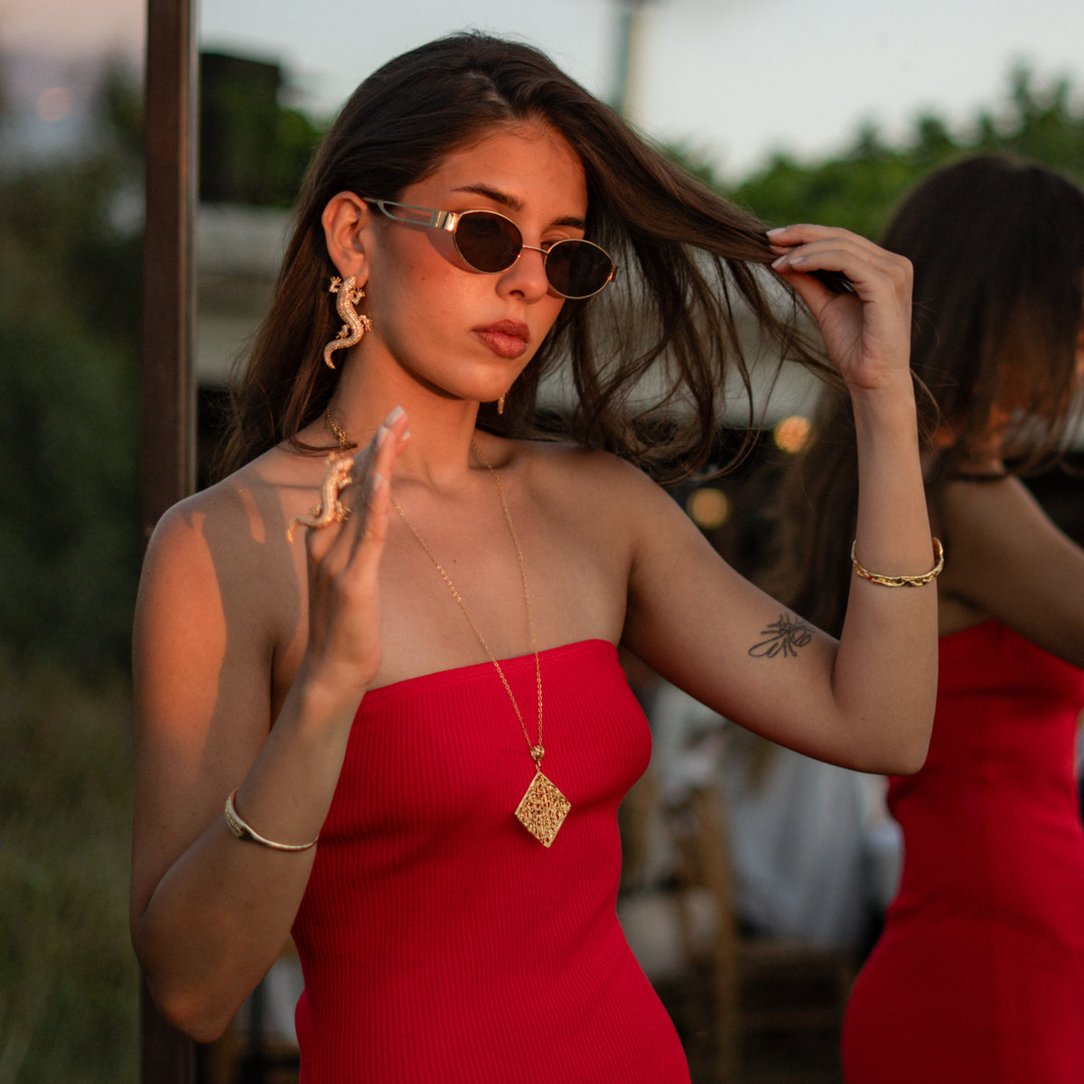 Woman in a red dress wearing the Crocodile Pave Zircon Gold Statement Ring with the matching crocodile earrings
