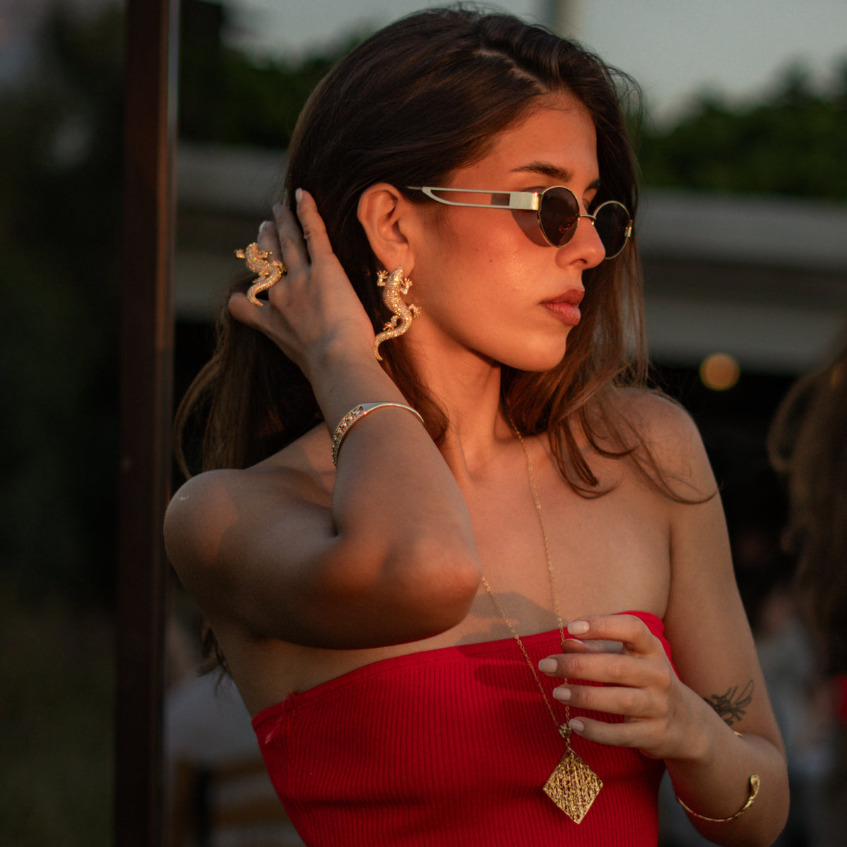 Model at sunset wearing the Crocodile Pave Zircon Gold Statement Ring and the matching statement earrings