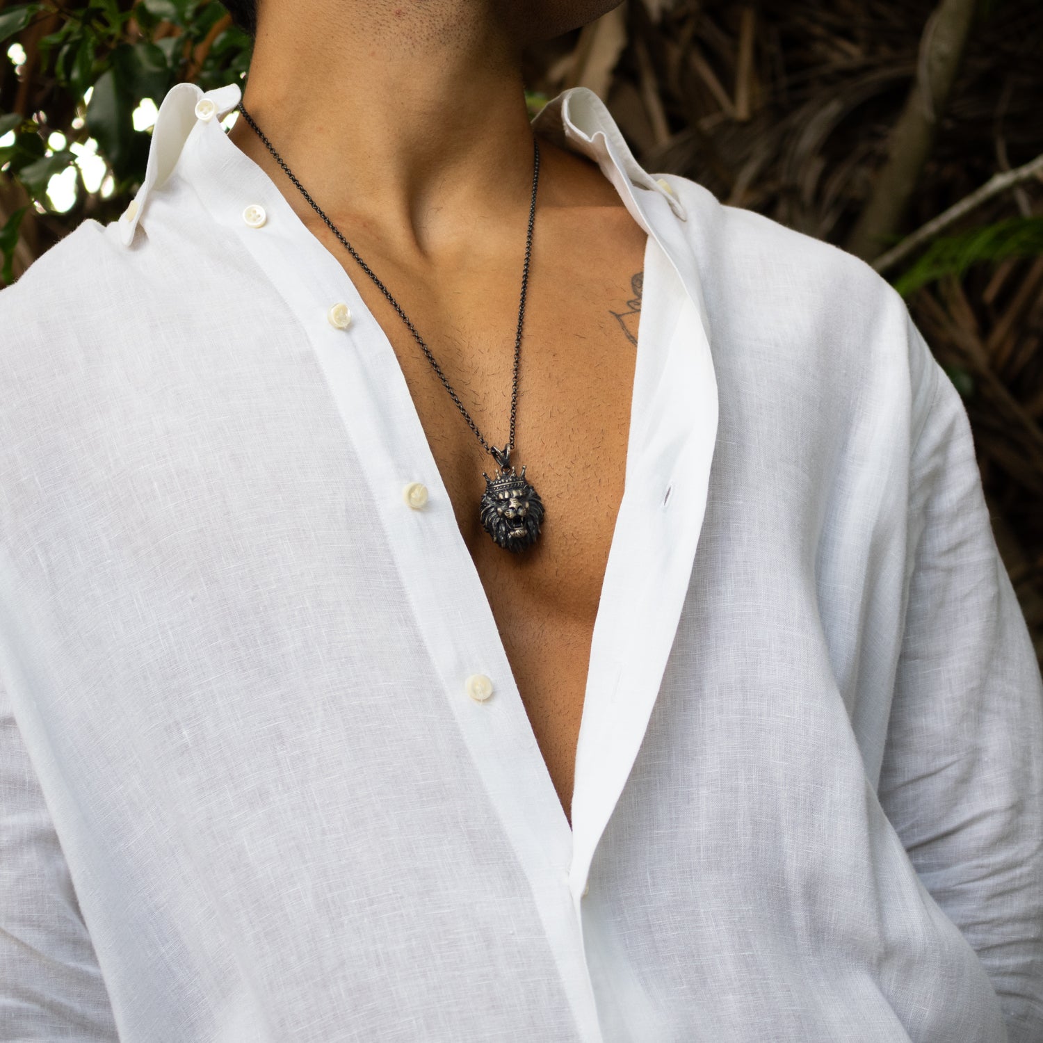Sterling silver necklace with crowned lion head pendant, rhodium finish, black and silver details, regal, bold masculine style.